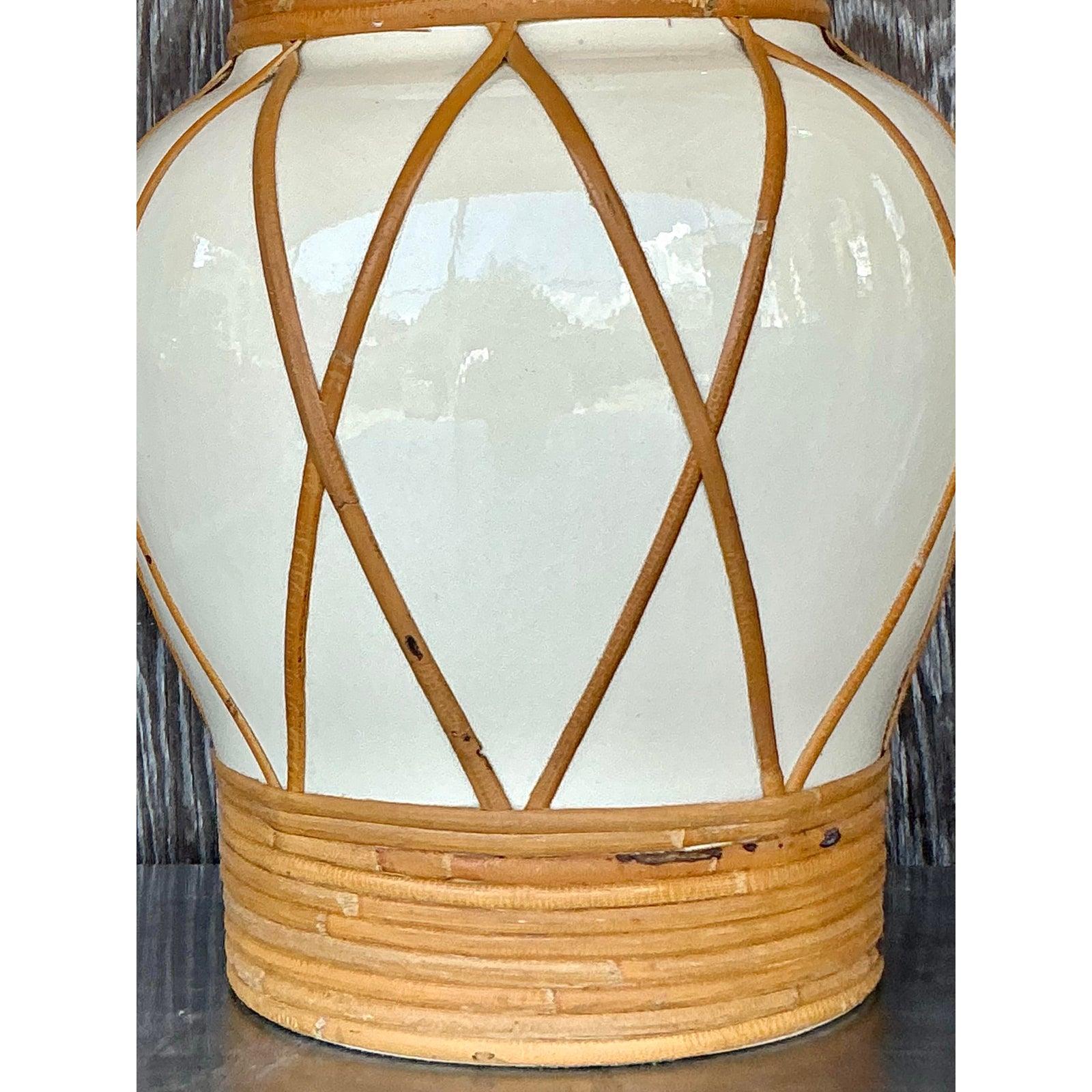 Bring organic warmth and oversized charm to your space with this vintage boho monumental rattan-wrapped urn lamp. Featuring a beautifully curved ceramic base in a creamy ivory finish, the piece is elevated by hand-applied rattan accents woven in a