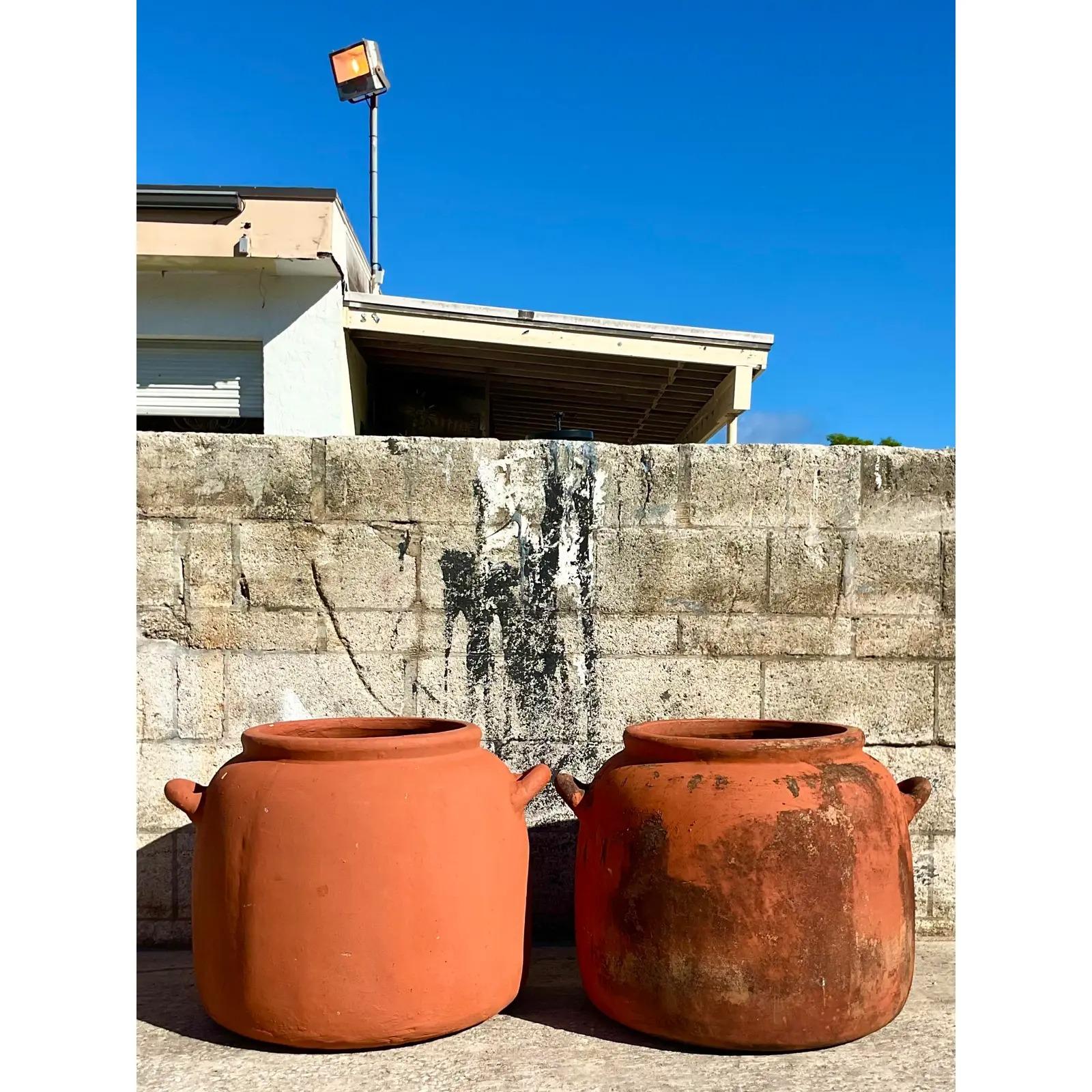 A fantastic pair of vintage boho planters. A chic modern urn design with a great all over patina. Acquired from a Palm Beach estate.