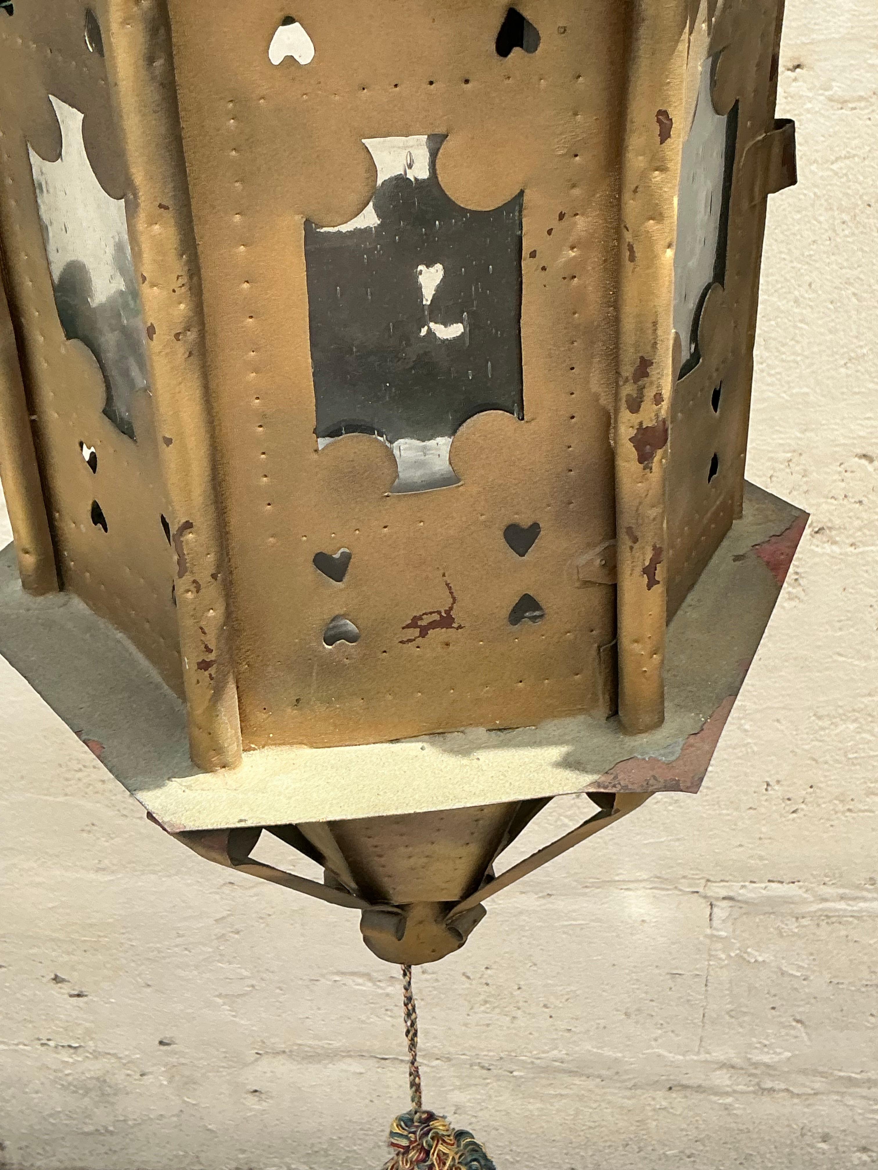 Illuminate your space with the exotic charm of these Vintage Boho Moorish Lanterns, inspired by Addison Mizner. This pair of American-style lanterns features intricate metalwork and a bohemian flair, adding a warm, enchanting glow and eclectic