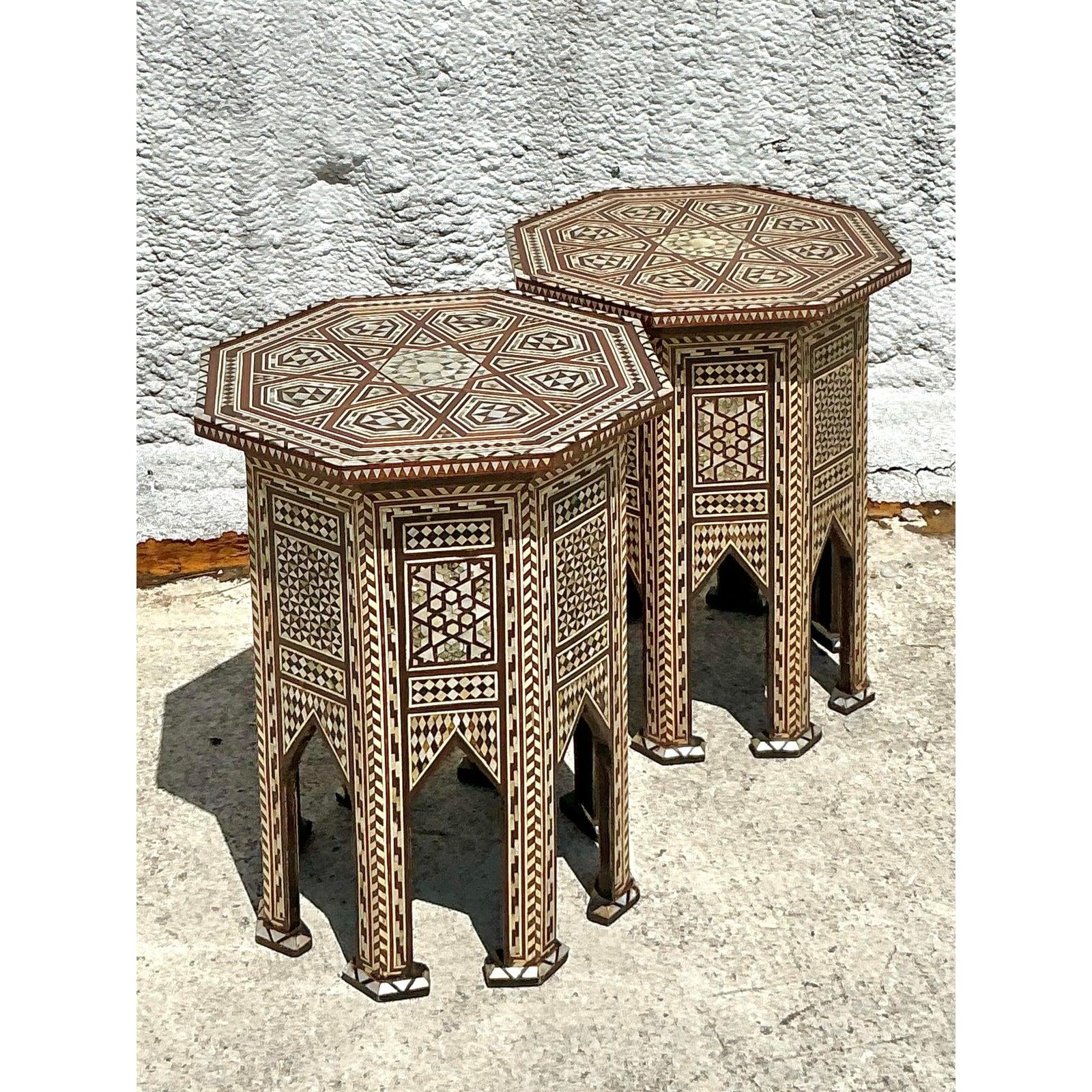 Transport your living space to an exotic locale with this breathtaking pair of vintage Moroccan inlay drinks tables. Each table is a testament to masterful artistry, featuring intricate geometric patterns meticulously handcrafted from what appears