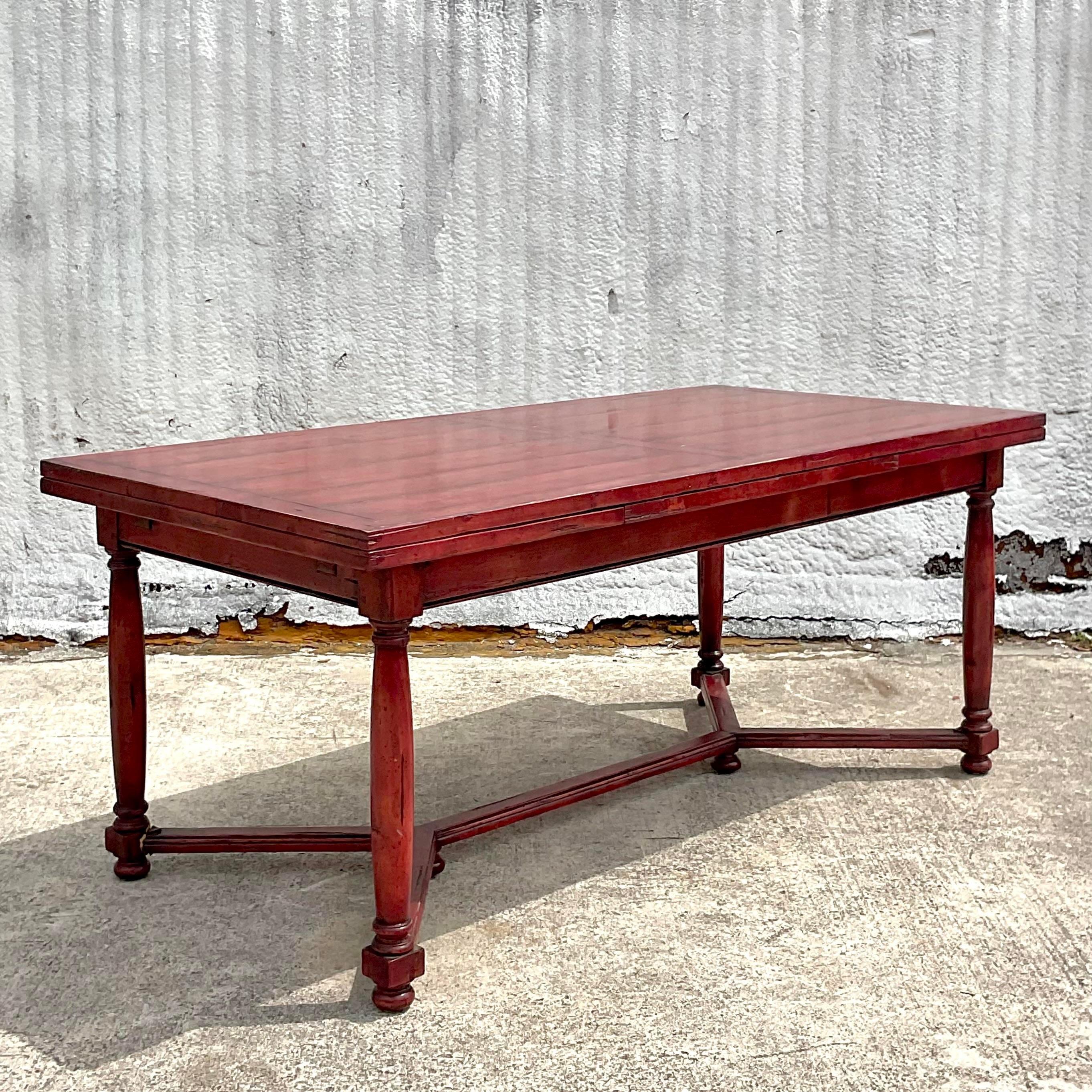A stunning vintage Boho dining table. A chic vintage reclaimed wood farm table with extendable sides. Painted a brilliant Moroccan red. Acquired from a Palm Beach estate.