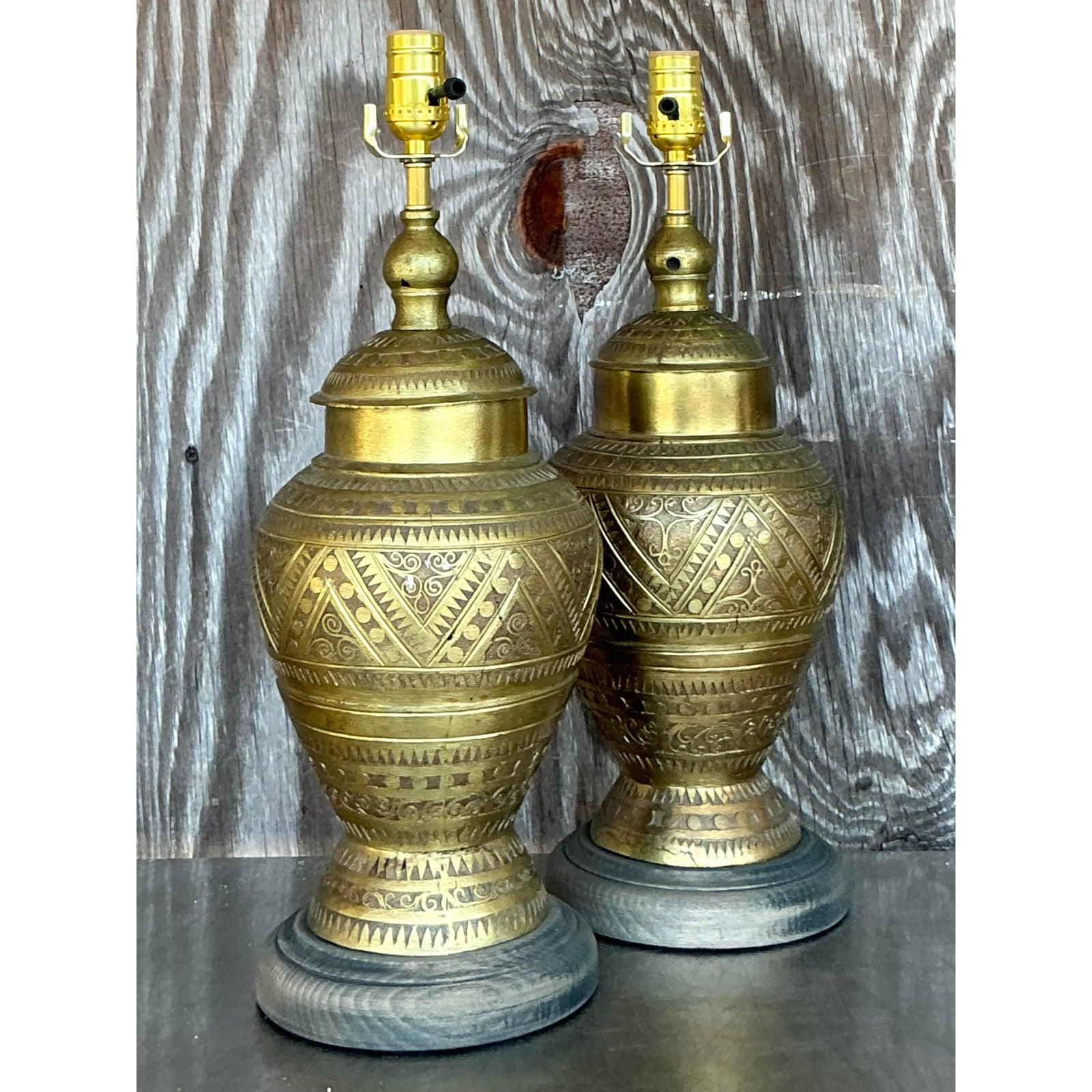 Aporta un toque de exótica elegancia y cálido ambiente a tu hogar con este cautivador par de Lámparas Vintage Boho Marroquí Tooled Brass. Fabricadas en latón brillante, las bases de las lámparas están adornadas con intrincados motivos tallados a