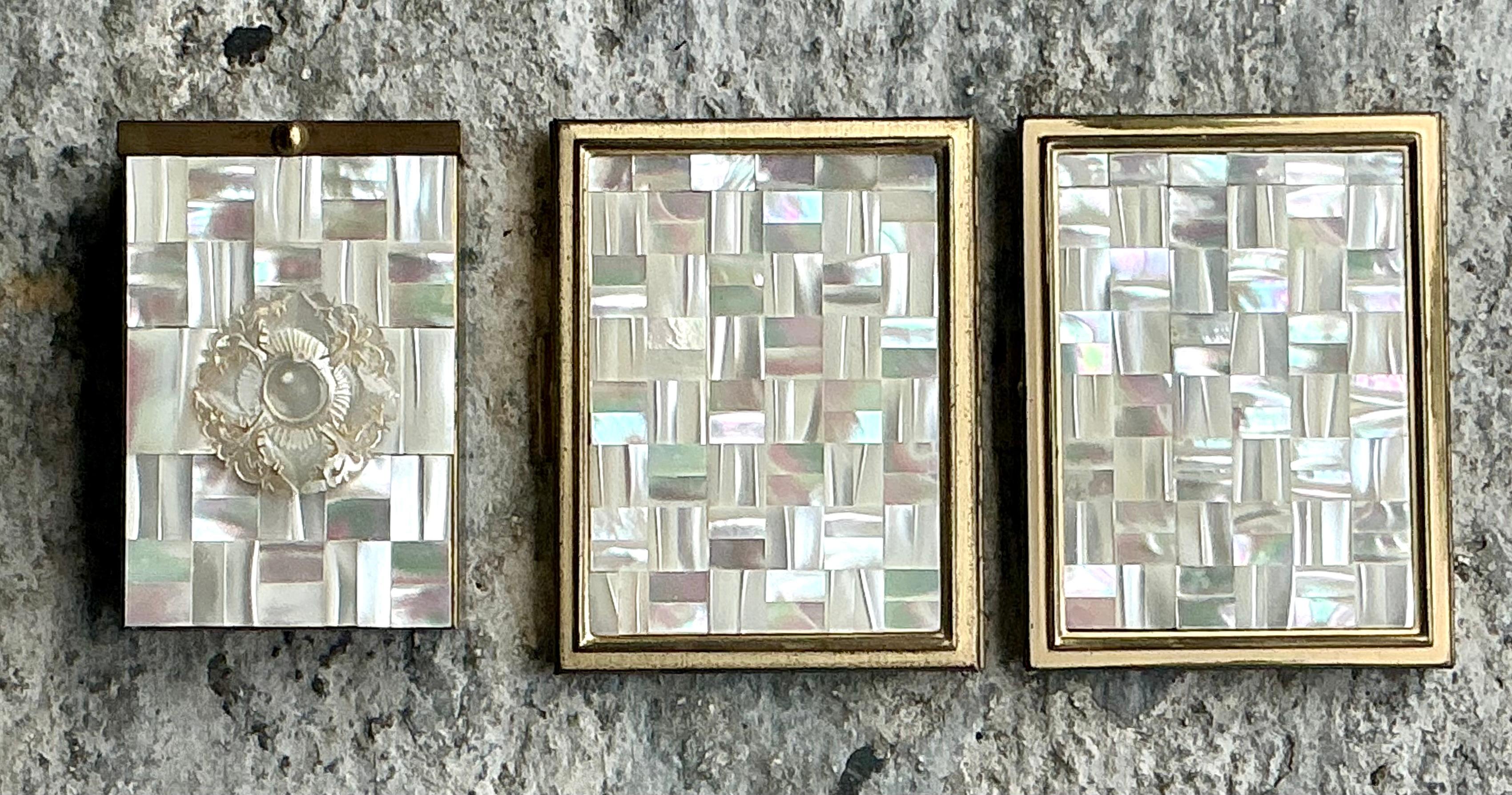 Add a touch of timeless elegance to your vanity with this stunning set of three vintage Boho Mother of Pearl compacts. Each compact showcases exquisite craftsmanship, featuring intricate inlays of iridescent mother of pearl that shimmer with natural