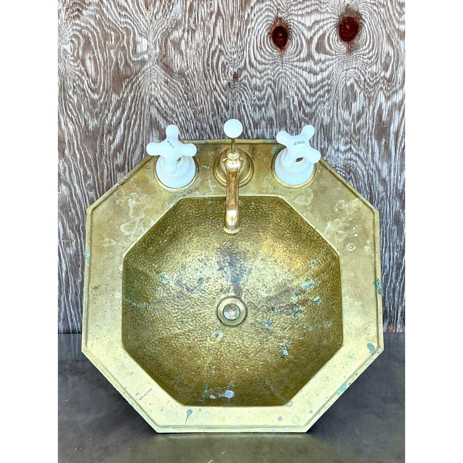 Elevate your bathroom or powder room with the unique charm of this vintage octagonal sink, beautifully crafted from hammered brass and complete with its original faucet set. The artisanal quality of the hand-hammered brass lends a rich texture and a