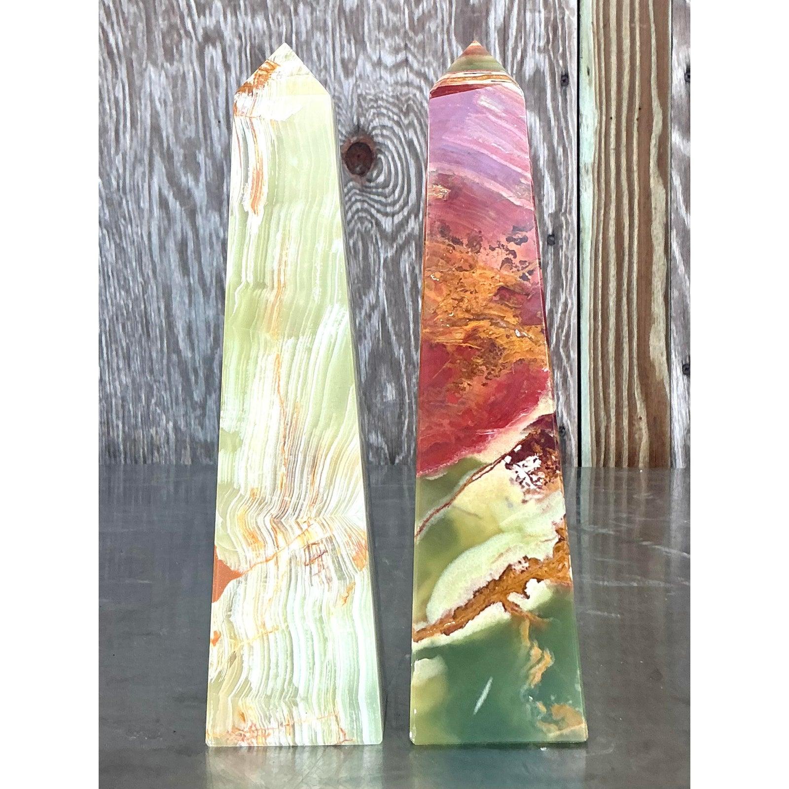 Command attention with this captivating pair of Vintage Boho Onyx Obelisks, a stunning testament to nature's artistry and expert craftsmanship. Each obelisk showcases unique, swirling patterns of vibrant multi-colored onyx, ranging from deep earthy