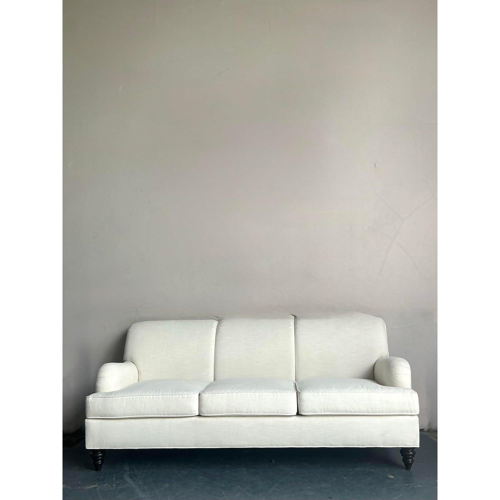 Discover this exceptional vintage Oomph sofa, a piece that effortlessly blends bohemian flair with sophisticated design. Upholstered in a chic white fabric, this sofa features subtle tufting that adds a touch of classic elegance to its relaxed,