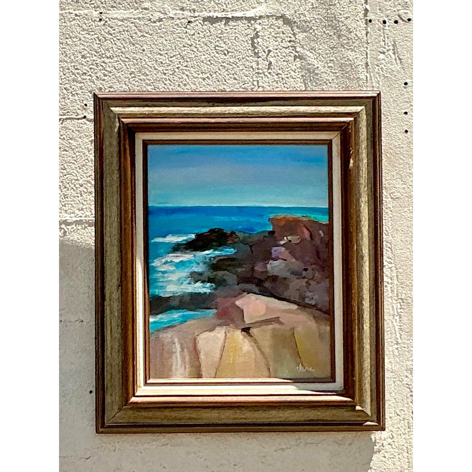 Capture the invigorating spirit of the coast with this captivating vintage seascape oil painting. An original work on canvas, it beautifully depicts a sunlit rocky shoreline meeting a vibrant turquoise sea under a clear blue sky. The impressionistic