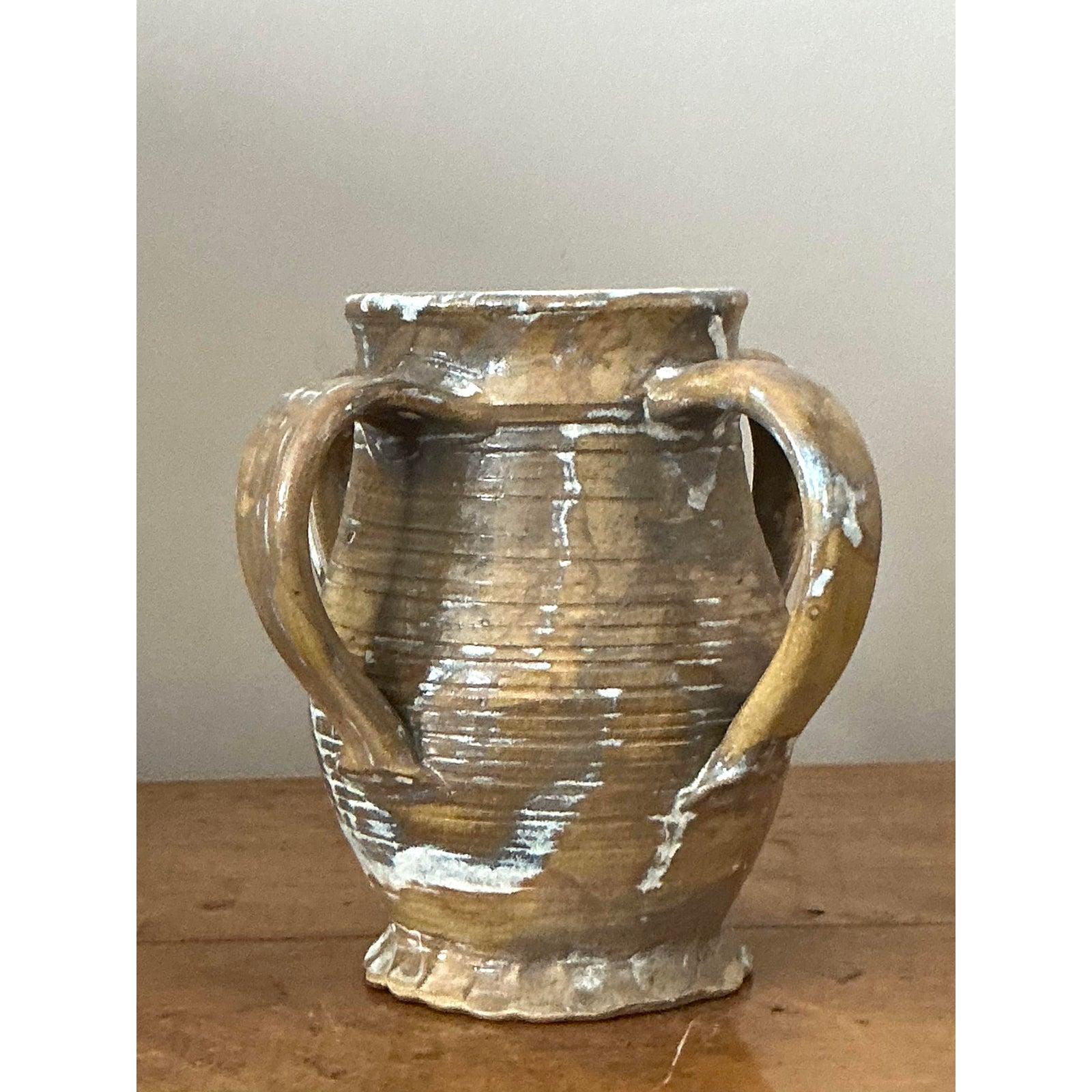 Evoca il fascino rustico di una villa mediterranea con questo affascinante vaso vintage in Studio Pottery. La sua forma classica ispirata all'anfora, completa di manici graziosamente spazzati e di un corpo splendidamente scanalato, mette in mostra