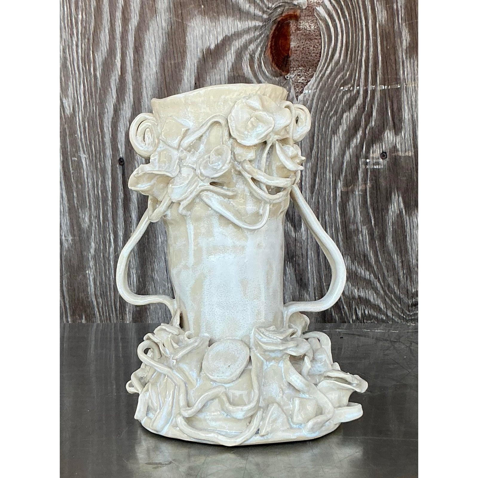 Celebra la forma stravagante e la fioritura scultorea con questo splendido vaso vintage in Studio Pottery. Questo vaso, costruito a mano, è caratterizzato da un intricato motivo a petali stratificati, con tralci simili a nastri ed elementi floreali
