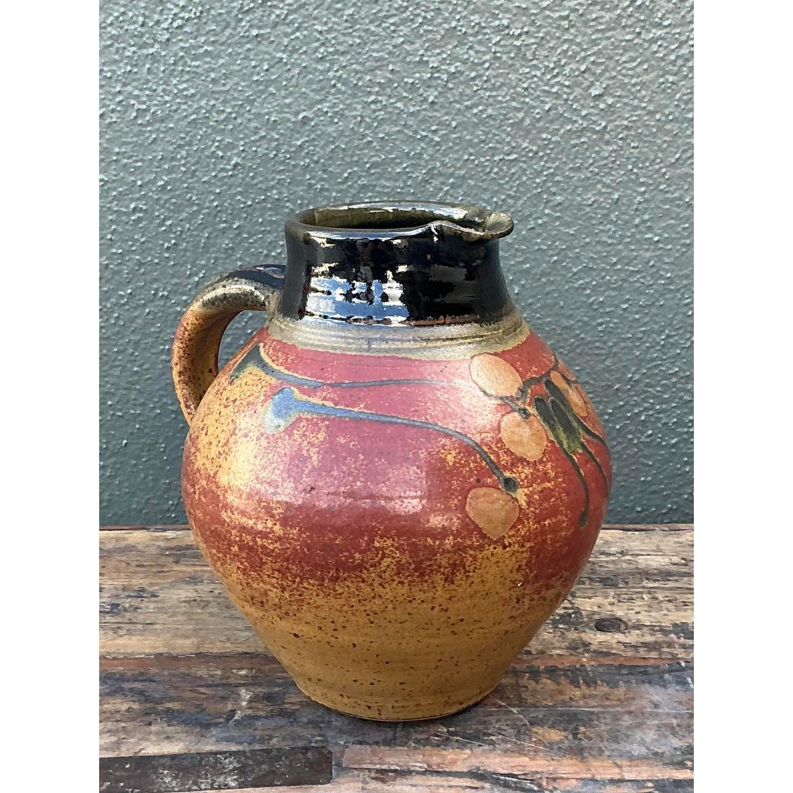 Infuse your home with the soulful energy of mid-century artisanal craft with this striking vintage studio pottery pitcher. Hand-thrown from robust stoneware, the vessel features a voluminous, globular body that tapers into a sturdy neck and spout.