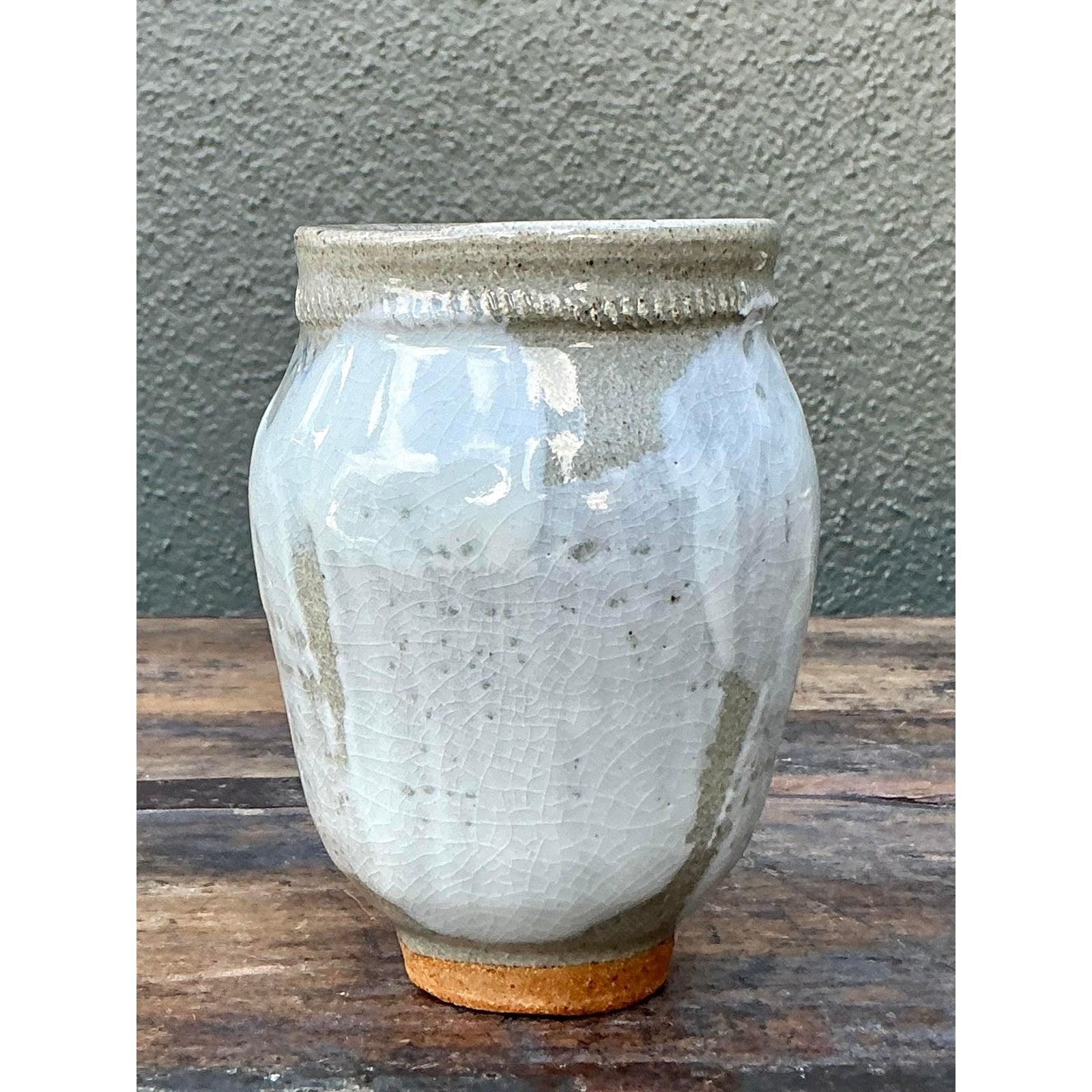 Abbraccia la serena bellezza dell'estetica Wabi-Sabi con questo squisito vaso vintage in Studio Pottery. Realizzato a mano con precisione, il vaso presenta un corpo in grès screziato di farina d'avena parzialmente avvolto da uno spesso e viscoso