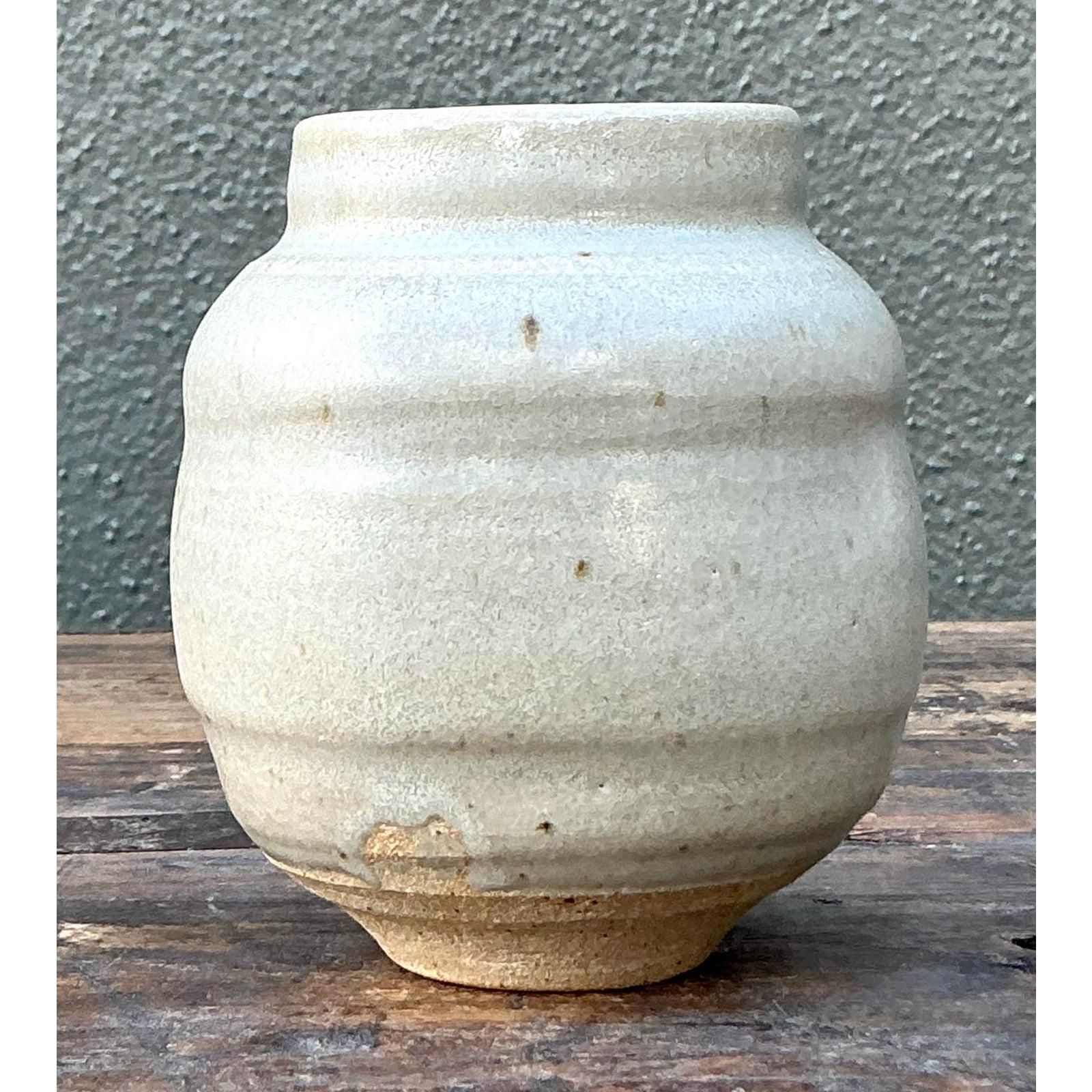 Introduci un tocco di serena bellezza architettonica nel tuo arredamento con questo squisito vaso vintage di Studio Pottery. Realizzato a mano con precisione, il vaso presenta una silhouette piacevolmente bulbosa, simile a un alveare, che si