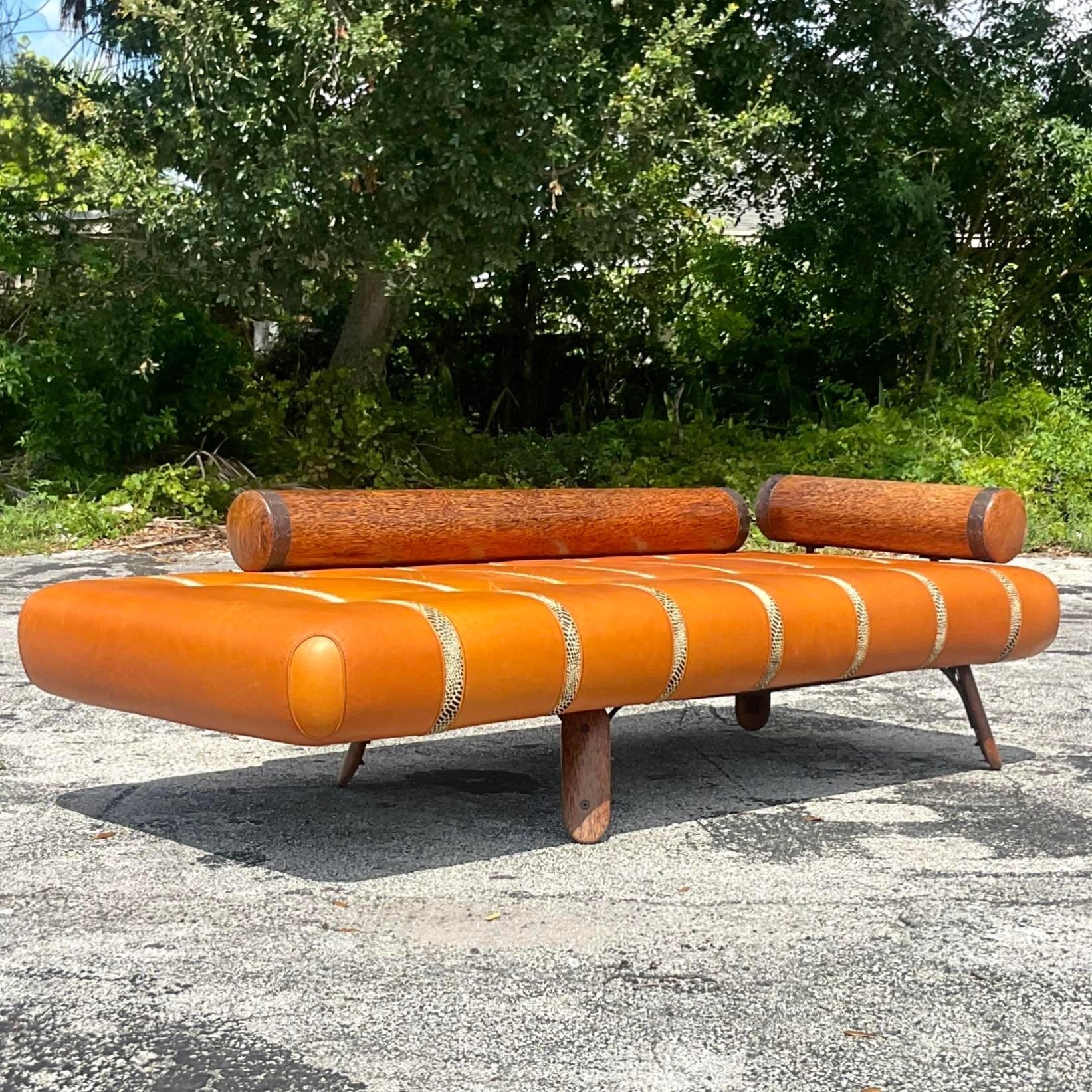 A fabulous Boho chaise lounge. Made by the iconic Australian group Pacific Green. Gorgeous leather upholstery with printed python leather inset strips. 40 year old palm Tree trunks used for the back and side bolsters. A real work of art. Acquired