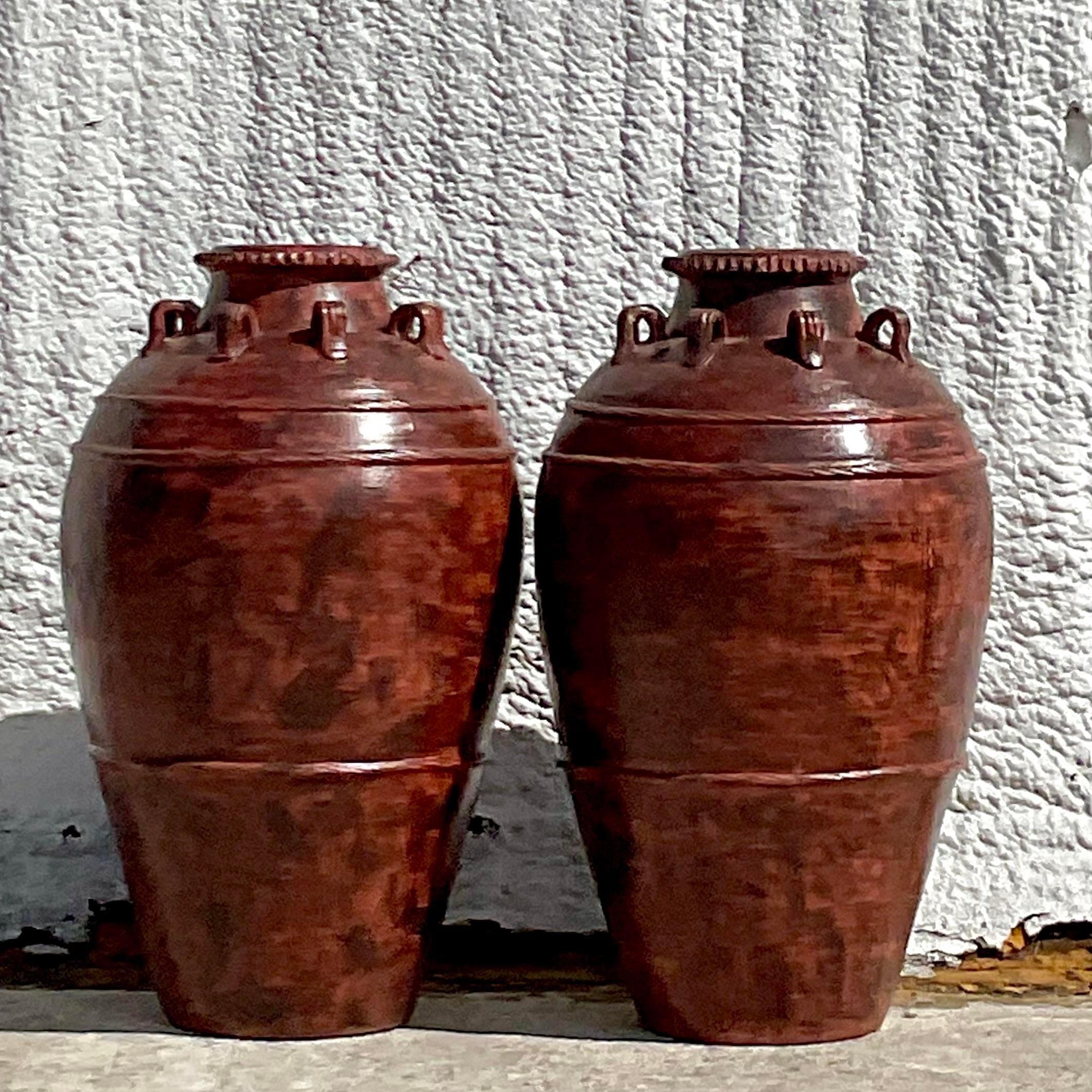 A fabulous pair of vintage Boho urns. Chic hand painted finish in a warm brownish rust color. Perfect indoors or outside in a covered area. Acquired from a Palm Beach estate.
