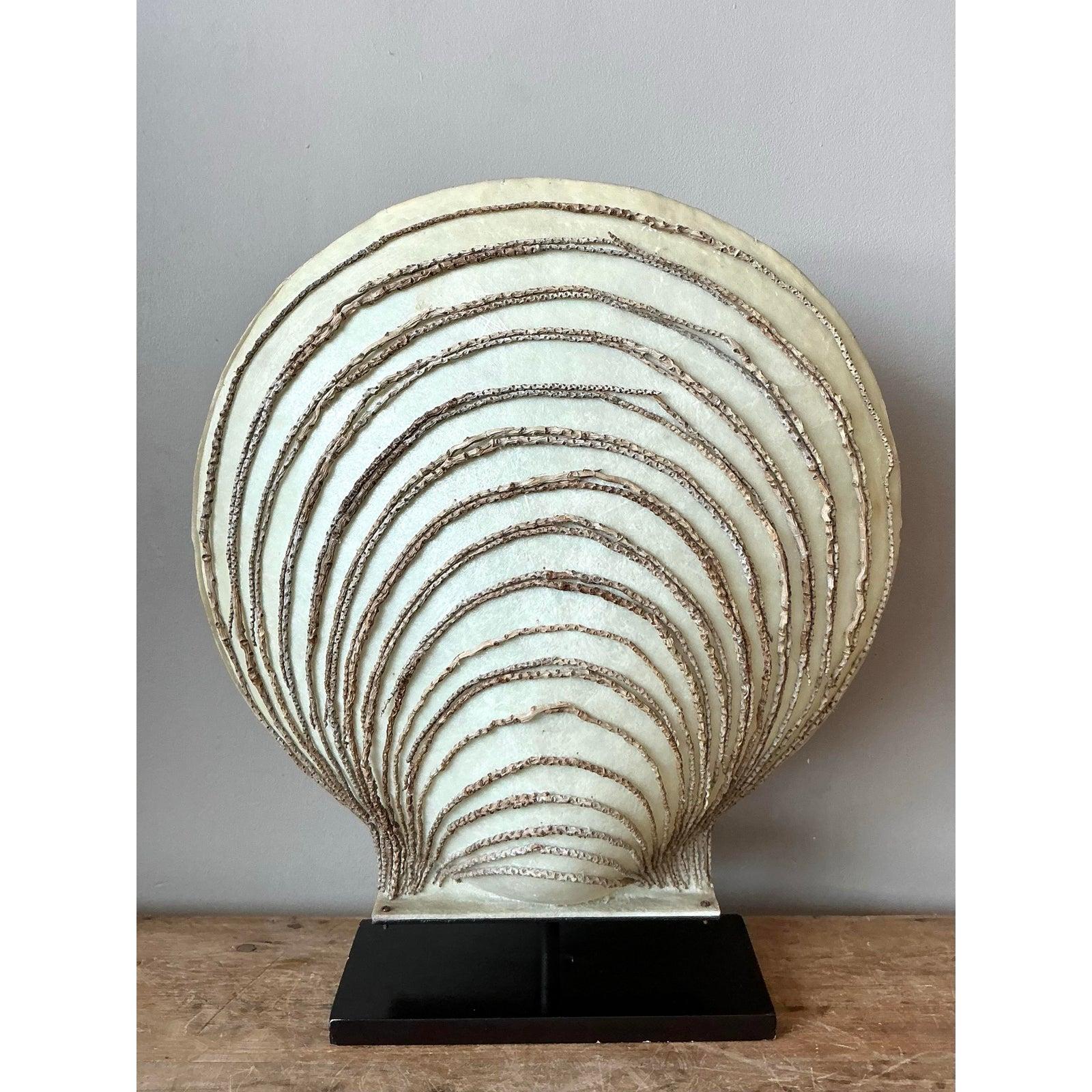 Illuminating sculpture meets coastal elegance in this dramatic vintage parchment clamshell table lamp. A striking example of Postmodern design with Art Deco influences, the lamp features a grand, fan-shaped scallop silhouette constructed from