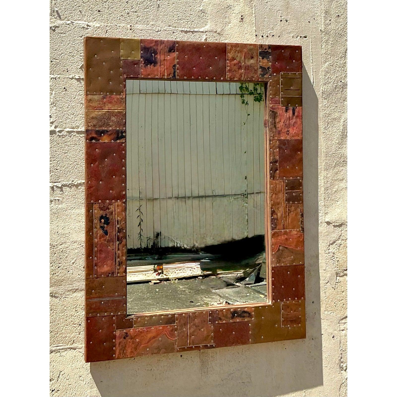 Aggiungi un tocco di espressione artistica e di stile bohémien alle tue pareti con questo straordinario specchio in metallo patchwork vintage bohémien. La struttura è un'accattivante composizione di vari pezzi di metallo, sapientemente uniti in un