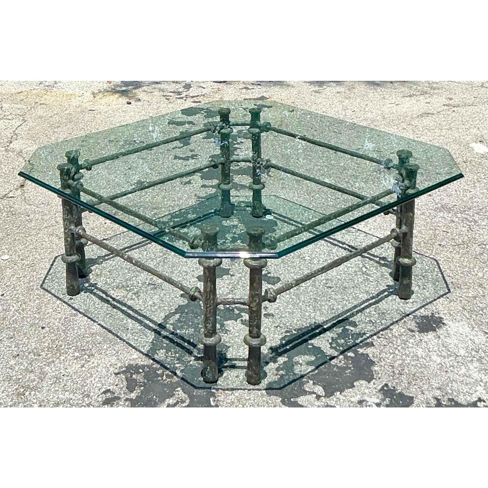 Evoking the raw, sculptural artistry of Diego Giacometti, this vintage coffee table is a masterpiece of Brutalist design. The table's focal point is its incredible patinated bronze base, featuring a complex network of legs and stretchers with