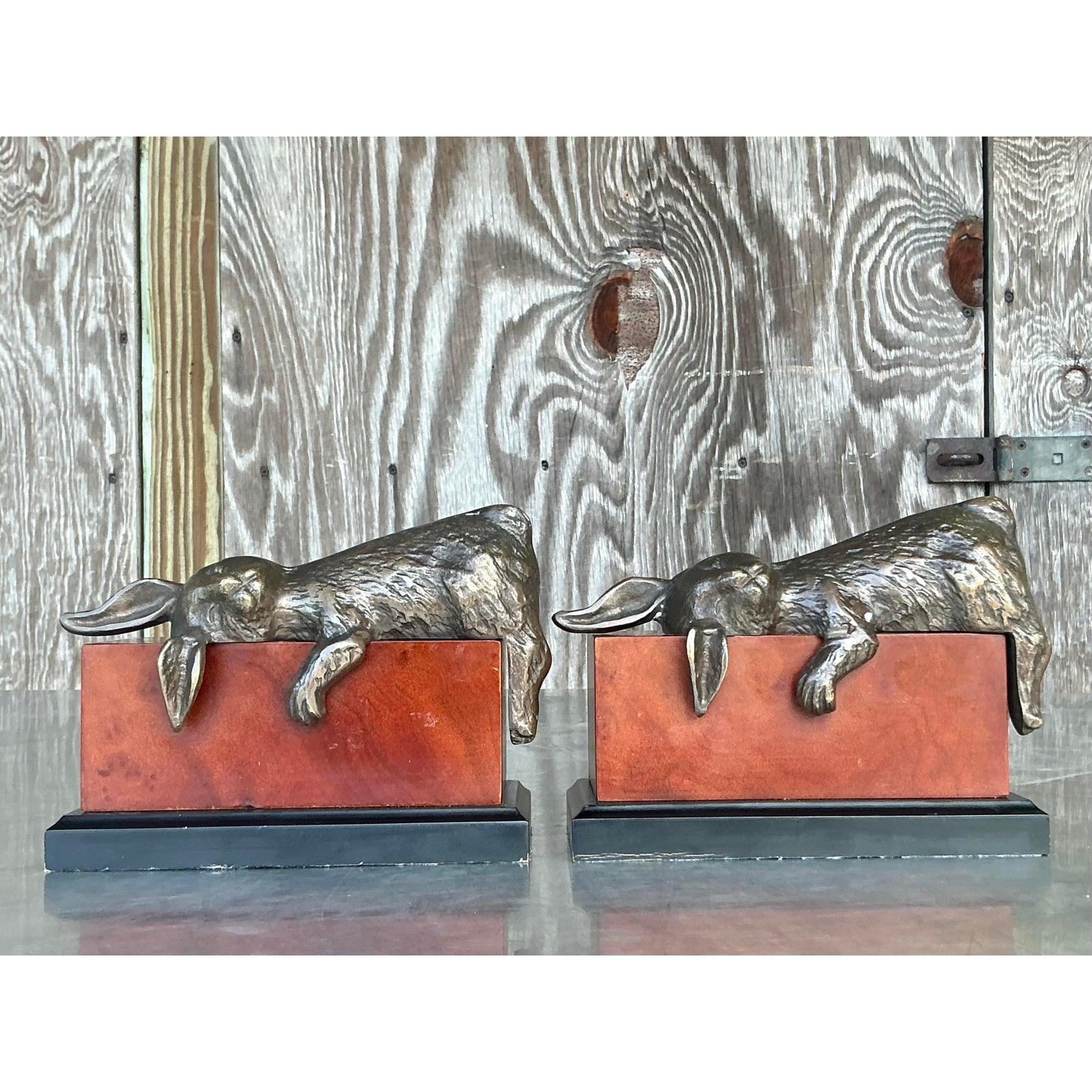 Descubre un toque encantador para tu colección con este exquisito par de Sujetalibros Boho Vintage de Bronce Patinado con Conejos sobre Bloques de Cuero. Cada sujetalibros presenta una encantadora y relajada escultura de conejo de bronce,