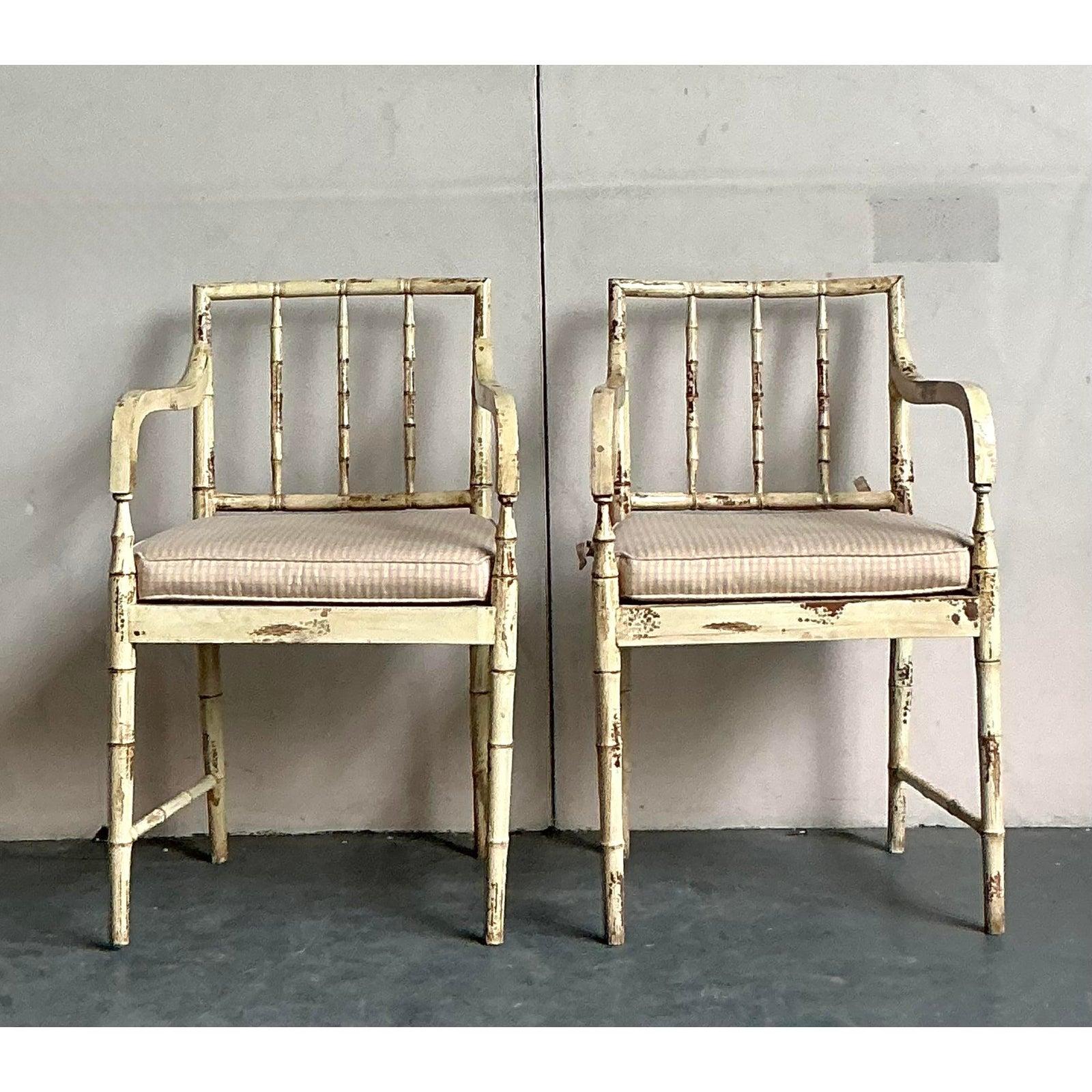 Embrace bohemian elegance with this charming pair of vintage armchairs, exuding a captivating patinated finish and distinctive faux bamboo detailing. Each chair features a beautifully woven cane back, offering both comfort and a touch of organic