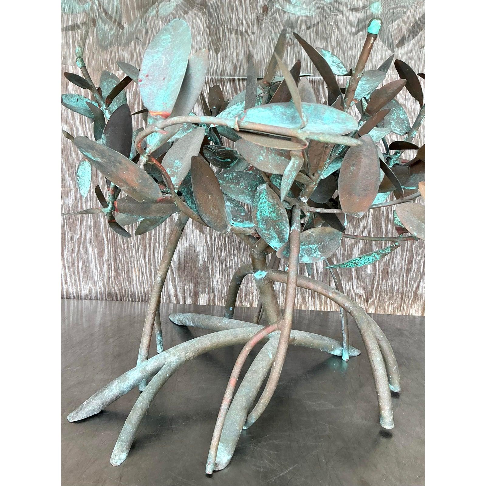 Cette table d'appoint vintage exquise est un chef-d'œuvre sculptural, doté d'une base complexe en cuivre patiné conçue pour ressembler à des racines de palétuviers enchevêtrées. La finition vert-de-gris magnifiquement altérée par les intempéries
