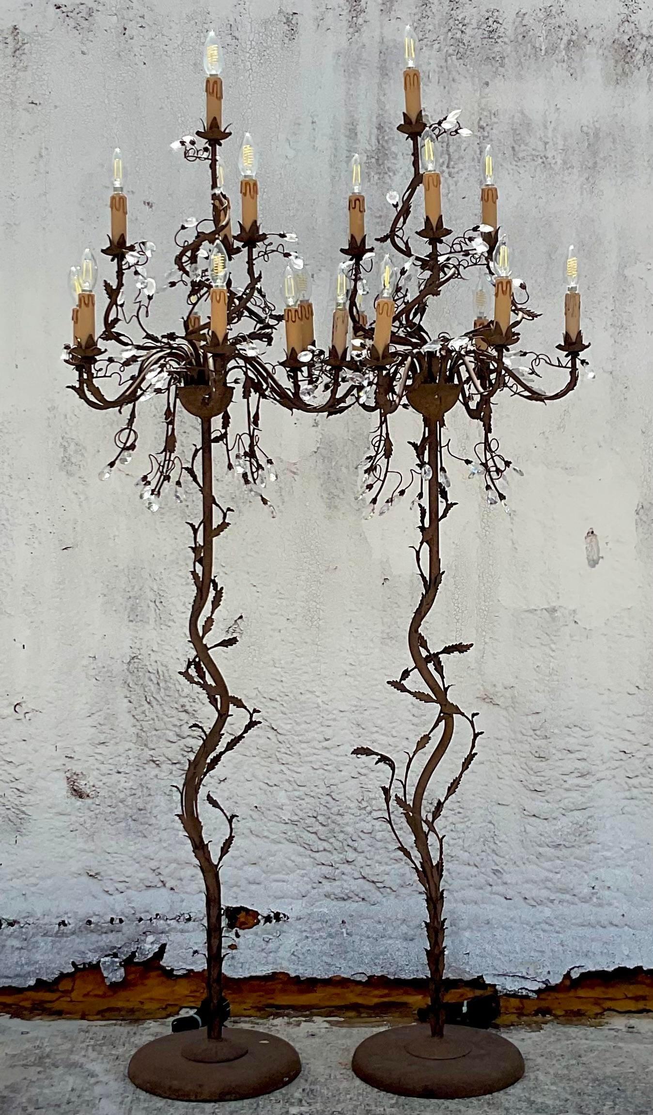 A fantastic pair of vintage patinated floor lamps. A chic chandelier design with crystal teardrops and chandelier shape. A fabulous rusty patinated finish. A perfect way to add a flash of romantic glamour to any space. Acquired from a Palm Beach