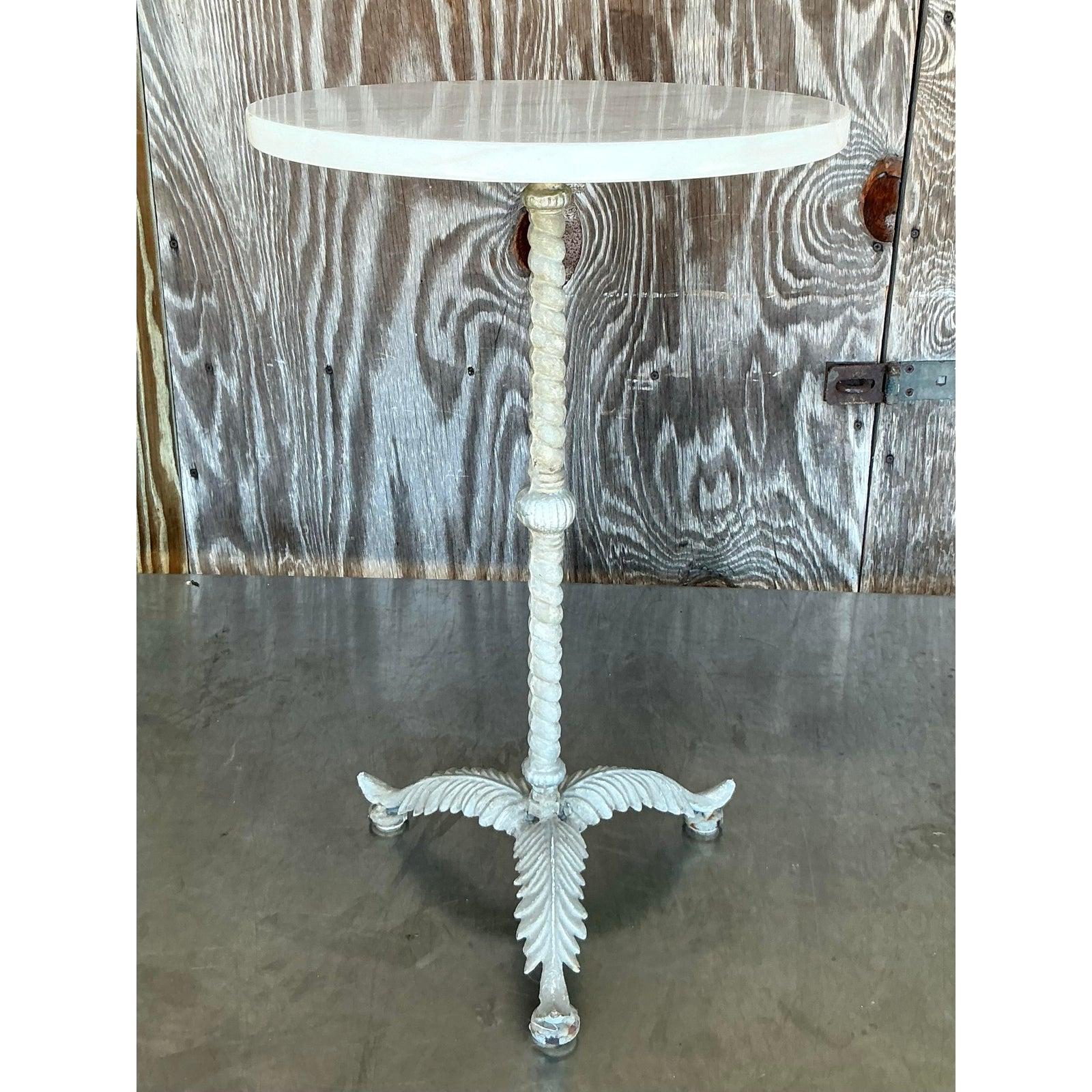 Eleva il tuo spazio abitativo con questo incantevole tavolino da bibita in piume patinate Vintage Boho, un pezzo d'accento davvero unico e pieno di carattere. Questo squisito tavolo presenta una base splendidamente dettagliata con piume stilizzate e
