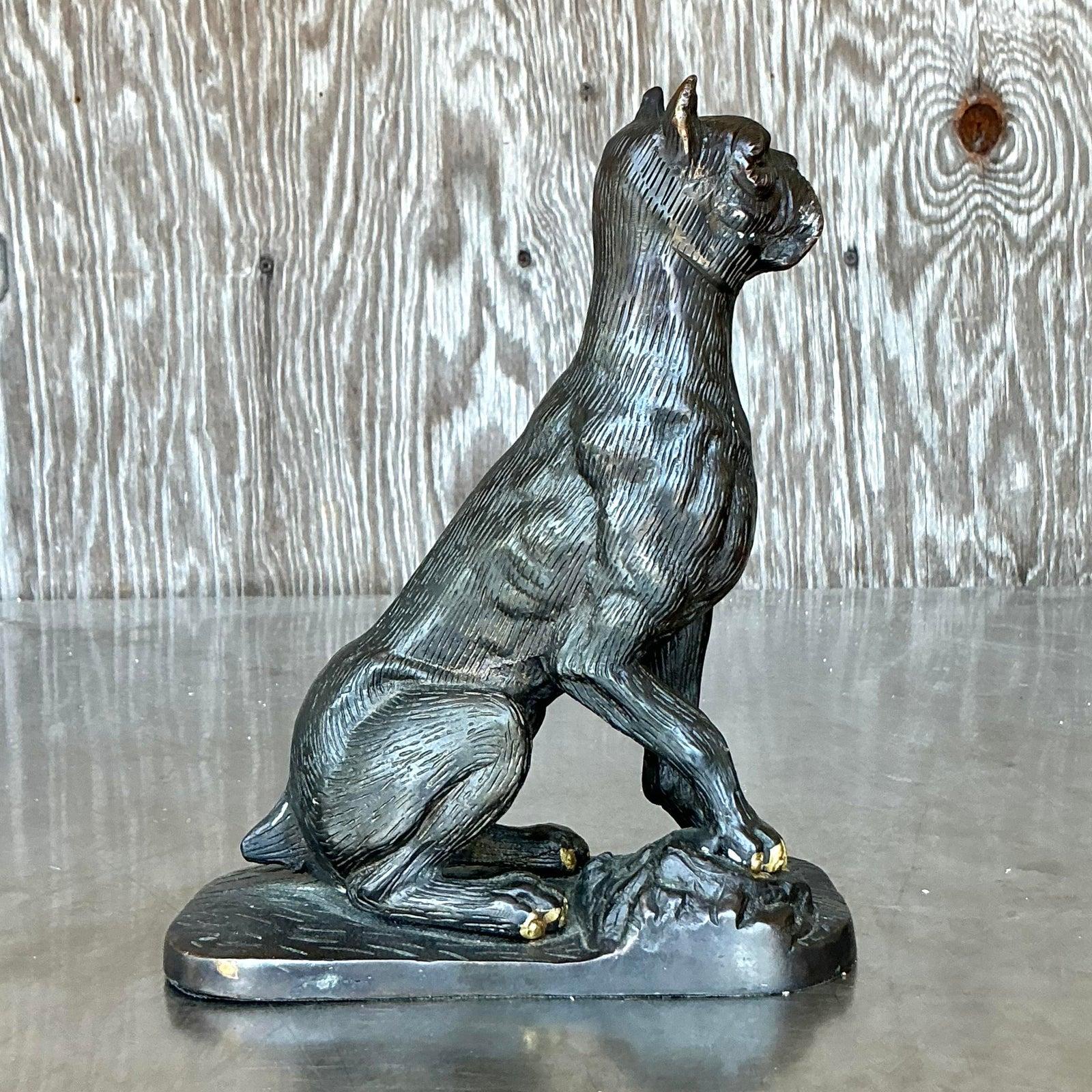 Add a touch of vintage charm and unique personality to your space with this delightful patinated metal sculpture of a seated dog. Crafted from metal, likely a bronze-toned alloy, this piece features a distinctive patinated finish that creates a rich