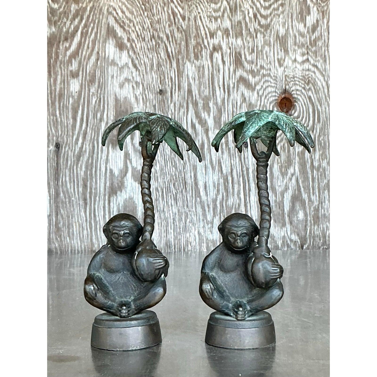 Aggiungi un tocco esotico al tuo arredamento con questa affascinante coppia di candelabri vintage in stile boho con scimmia patinata. Realizzati in metallo massiccio con finitura verdognola, questi stravaganti candelabri raffigurano scimmie sedute