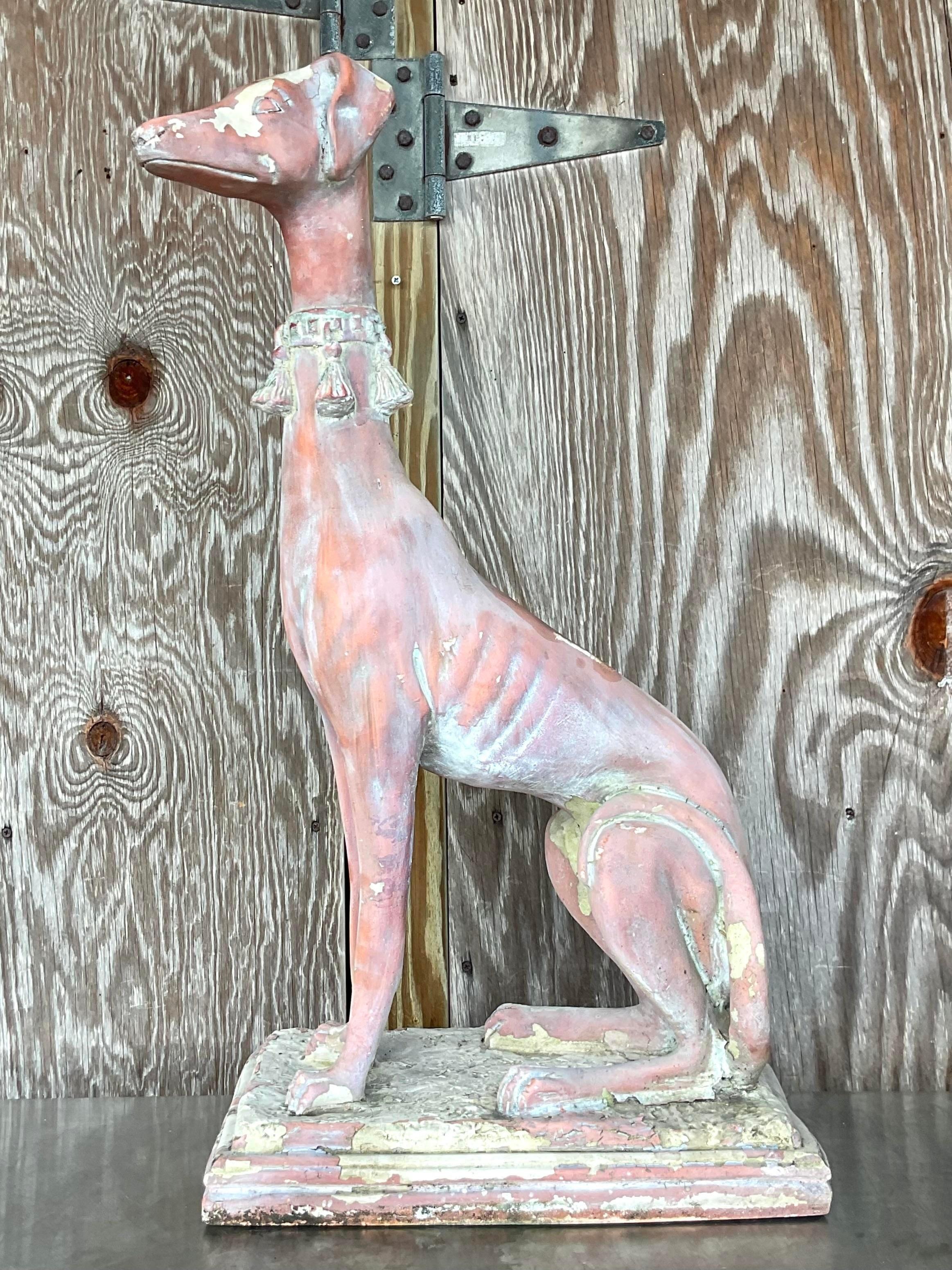Evoke the grace and charm of the past with this Vintage Boho Patinated Resin Greyhound Statue. With its weathered finish and timeless elegance, this statue captures the spirit of American bohemian style, adding a touch of vintage allure to any space.