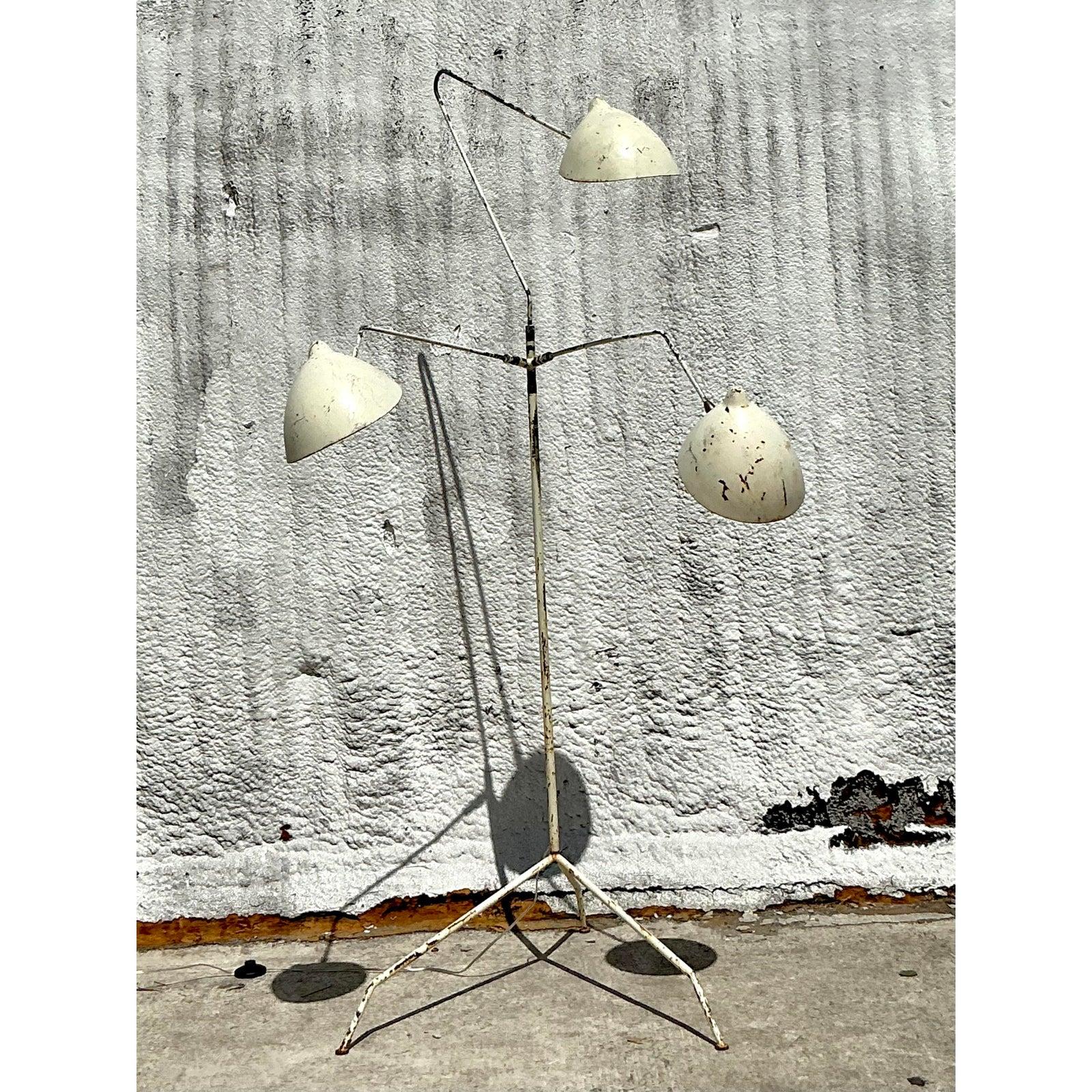 Make a bold statement with this vintage floor lamp, designed in the iconic style of mid-century master Serge Mouille. Its dramatic, insect-like form features three articulated arms branching from a central stem, each culminating in a rotating