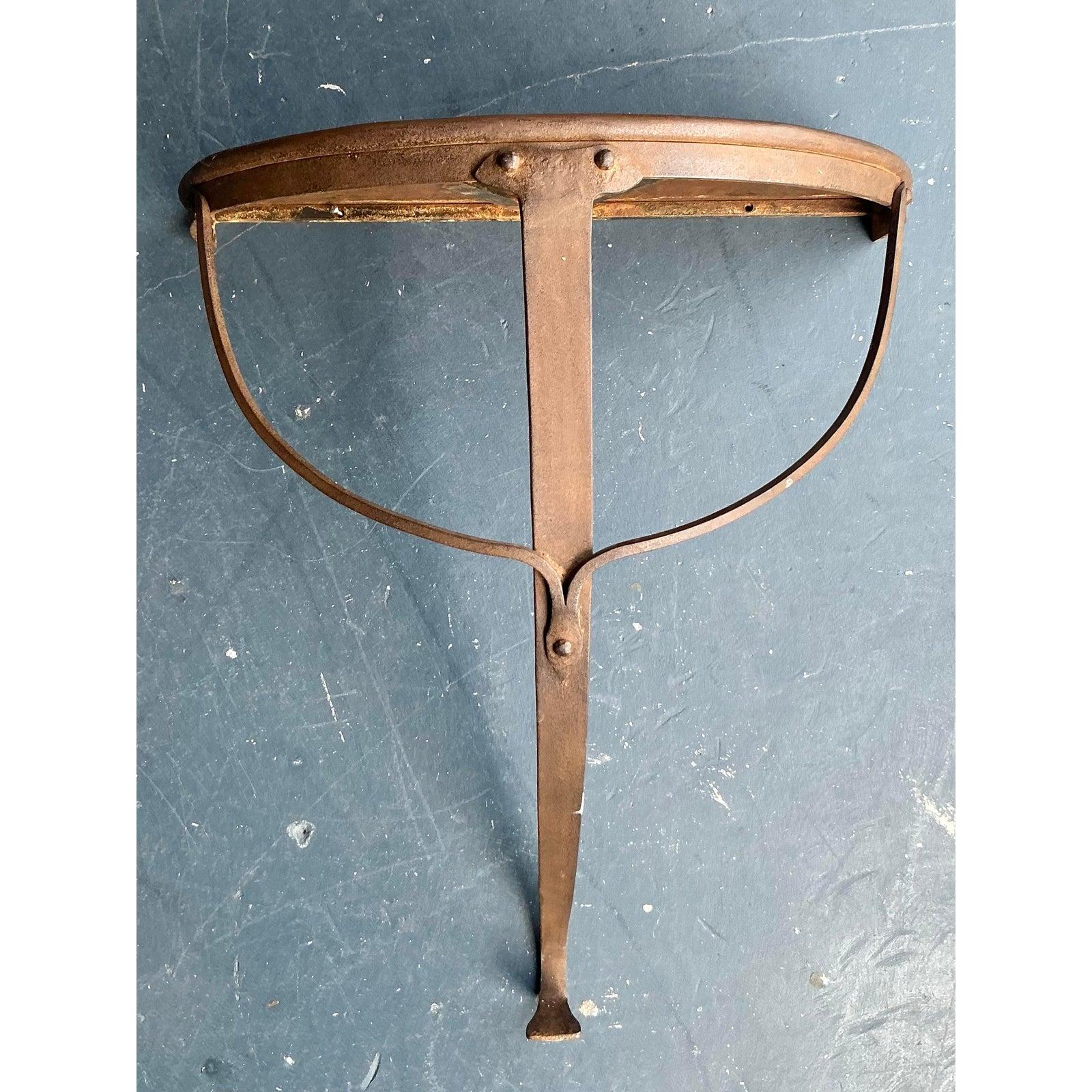 Discover a unique blend of rustic charm and bohemian sensibility with this vintage patinated cast iron wall mount demilune console table. Crafted with robust cast iron, its distinctive half-moon shape and distressed finish evoke a sense of aged