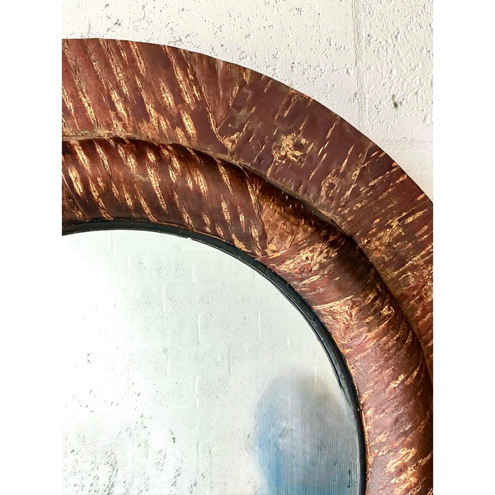 Introduce un elemento rico en texturas en tus paredes con este excepcional espejo vintage de madera tallada. El sólido armazón presenta un acabado profundamente patinado, casi Brutalista, mostrando una textura artesanal y rústica que invita al