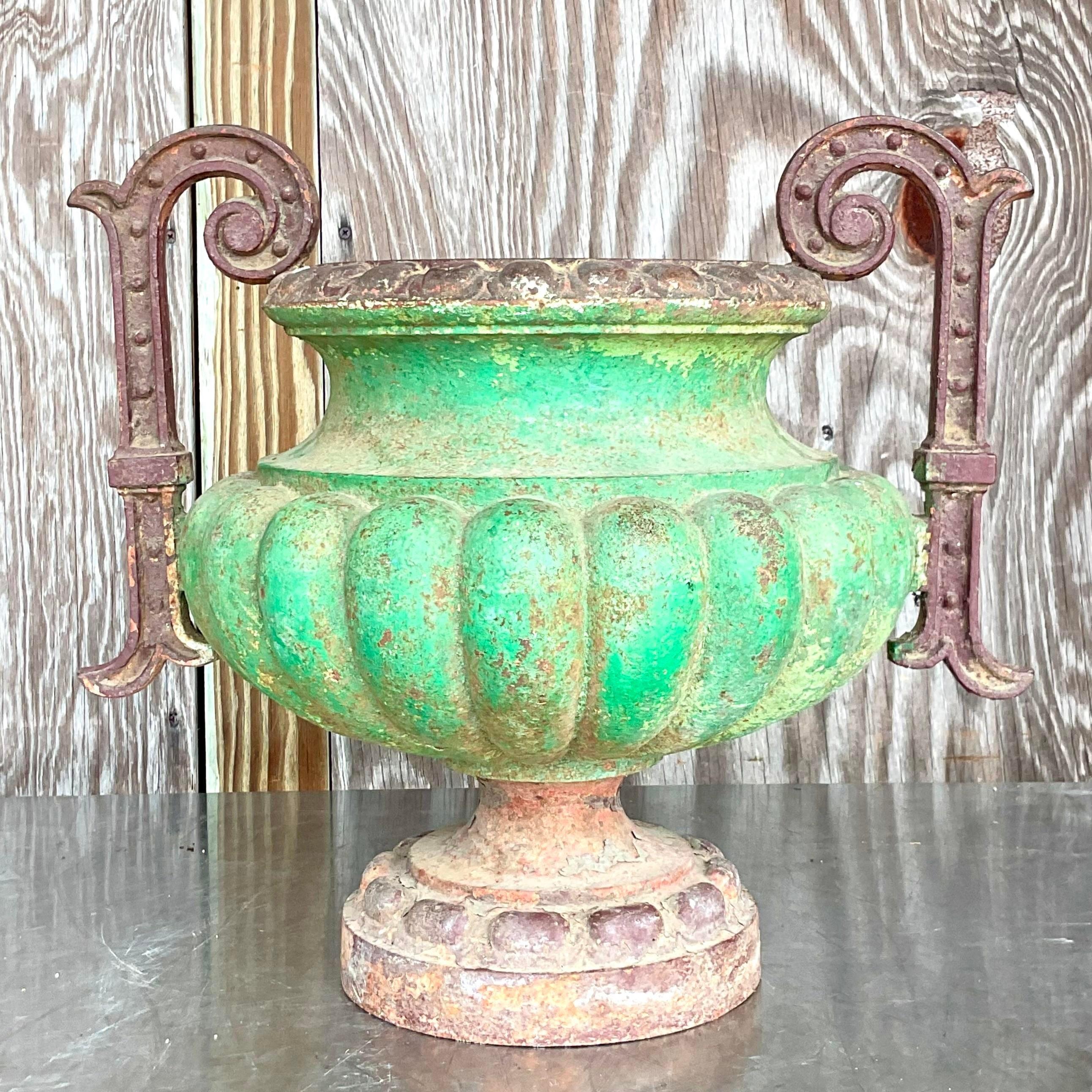 A fabulous vintage Boho urn. A chic patinated painted finish on a classic wrought iron shape. A brilliant green paint partially remains. Acquired from a Palm Beach estate. 