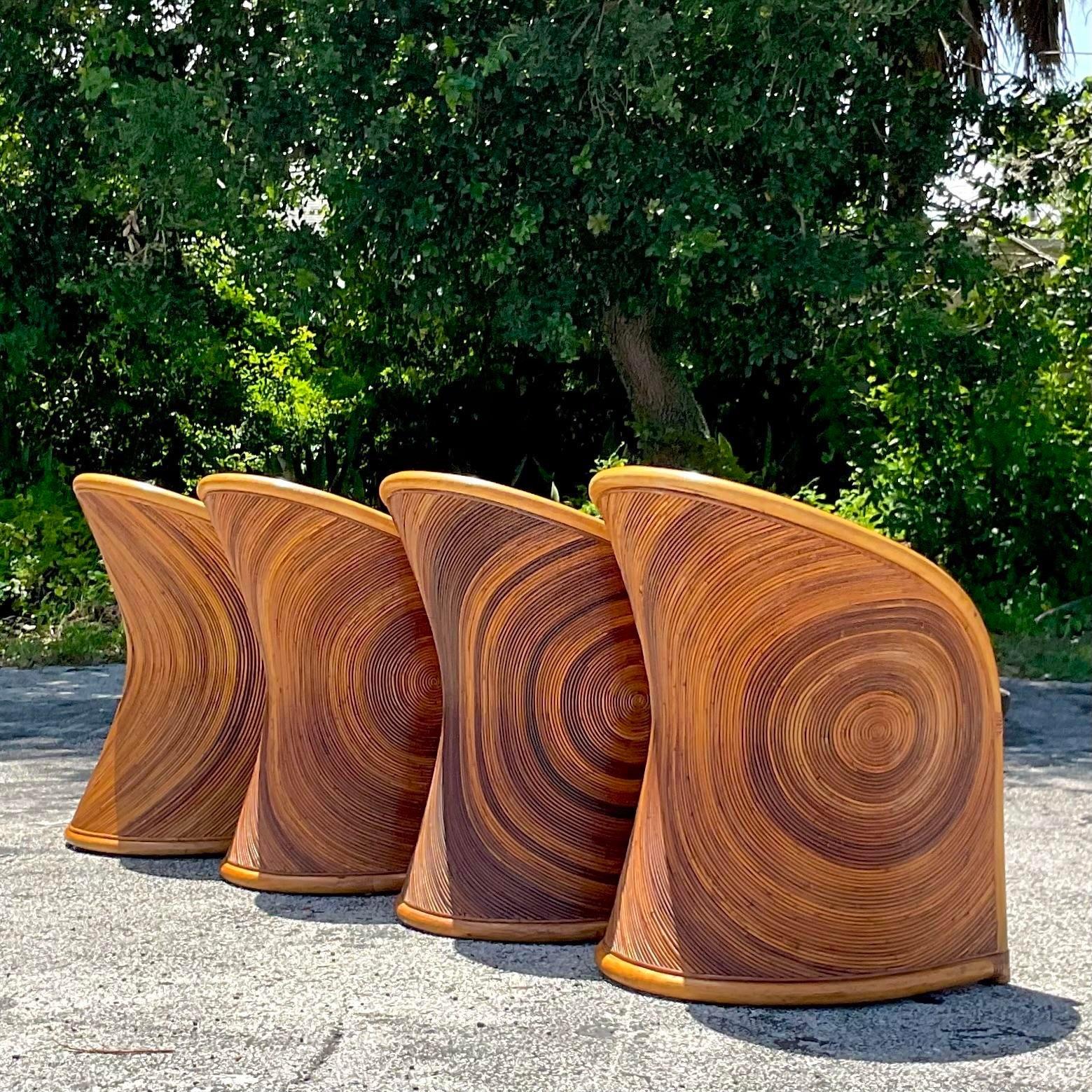 A extraordinary set of four vintage Boho dining chairs. The rare radiating sun design in pencil reed. A beautiful curved shape with a kick out back. Matching dining table also available on my page. Acquired from a Miami estate