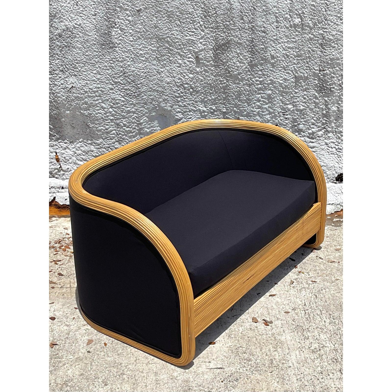 Abbraccia lo stile iconico del design degli anni '80 con questa poltrona vintage eccezionalmente chic in giunco. Questo pezzo, che sfoggia la ricercatissima silhouette a cascata, è definito dalla sua struttura in rattan impacchettato ad arte che si
