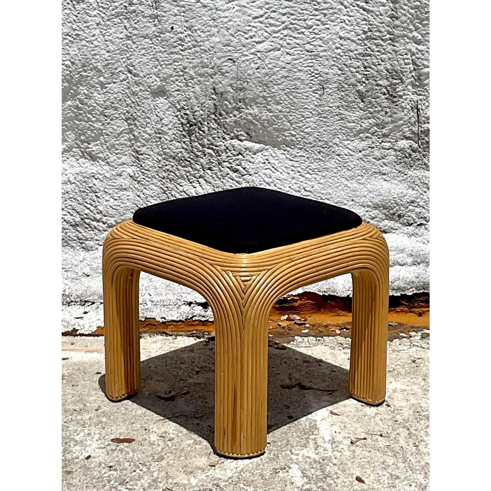 Completa il tuo salotto o introduci un tocco indipendente di stile scultoreo con questo pouf vintage in giunco. Incarnando lo spirito glamour del design degli anni '80, questo pezzo presenta l'iconico angolo a cascata, con il rattan meticolosamente