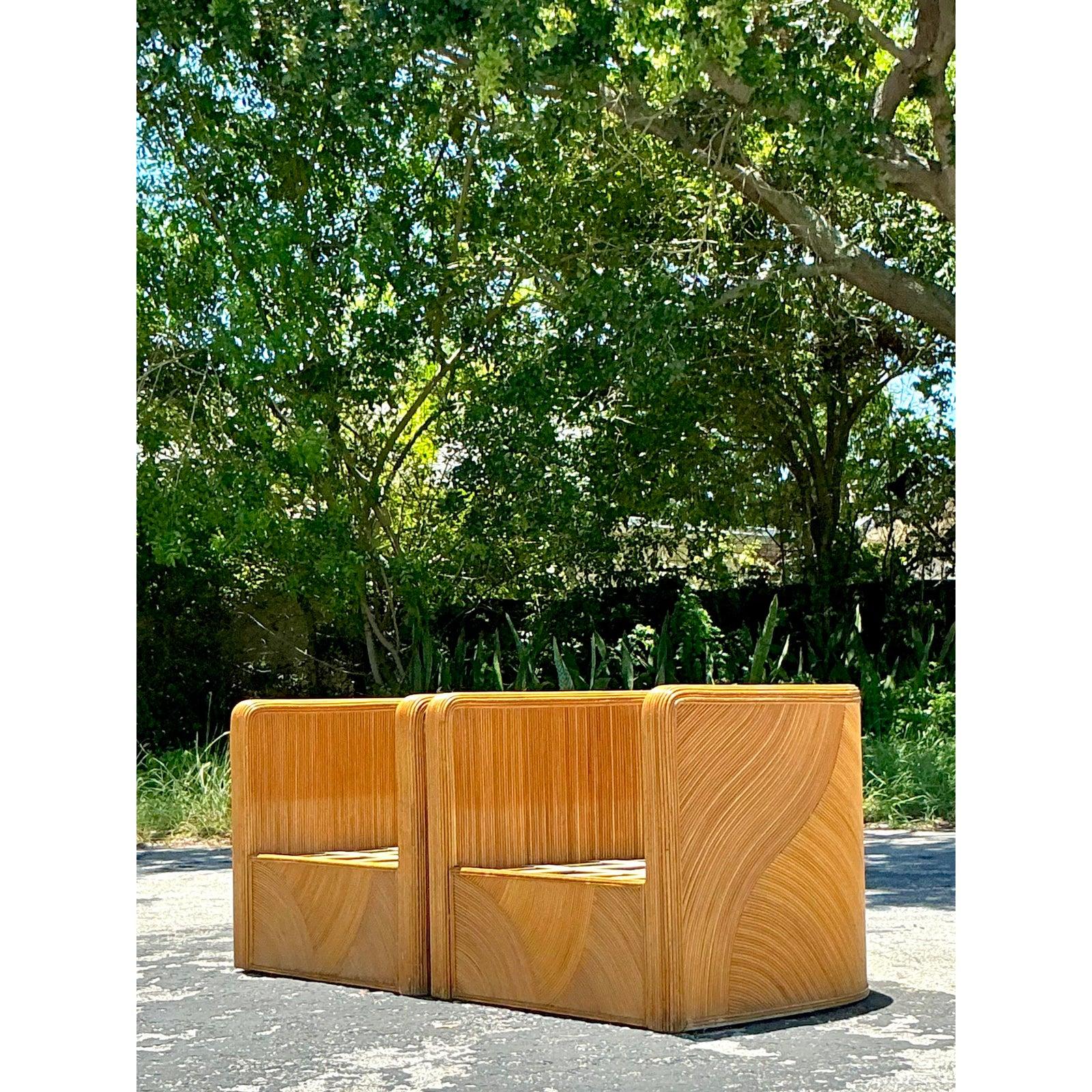Capture the essence of 1980s glamour with this exceptional pair of vintage tub chairs. Meticulously wrapped in pencil reed rattan, these chairs boast a stunning 