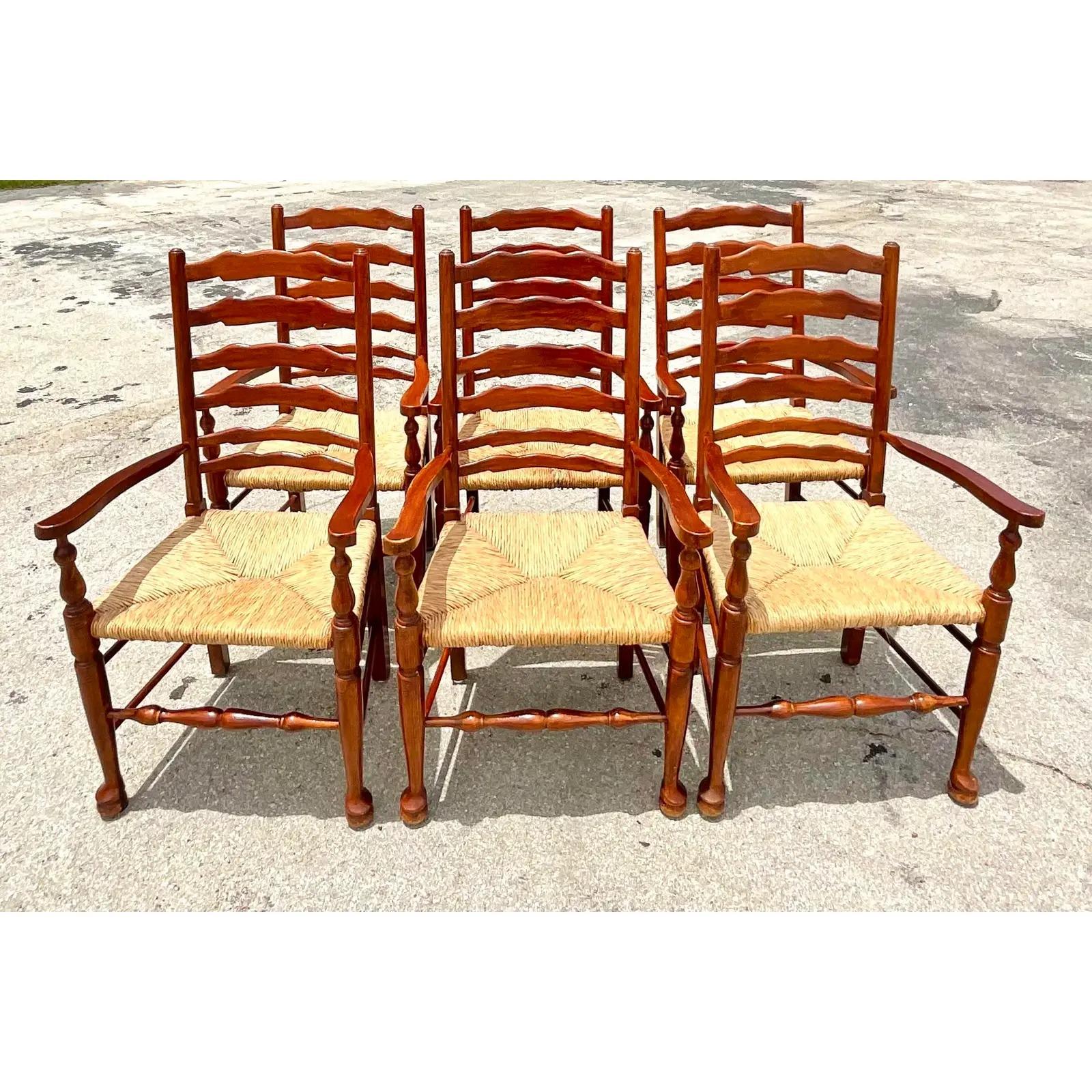 Fantastic set of vintage Boho dining chairs. Made by the iconic Pierre Deux group. Beautiful rush seats with a Classic ladder back design. Acquired from a Palm Beach estate.