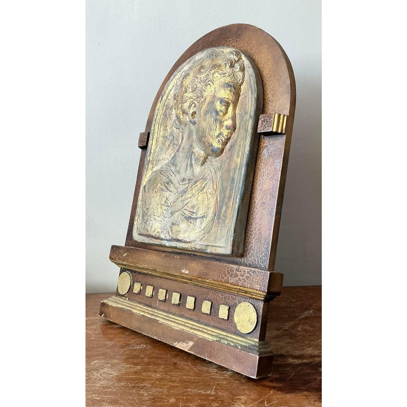 Wir präsentieren eine auffällige vergoldete Gipsrelief-Skulptur im Vintage-Stil, ein Stück, das klassische Kunstfertigkeit mit dem unverwechselbaren Flair der Art-Déco-Ära meisterhaft verbindet. Dieses Relief zeigt eine überzeugende männliche Büste