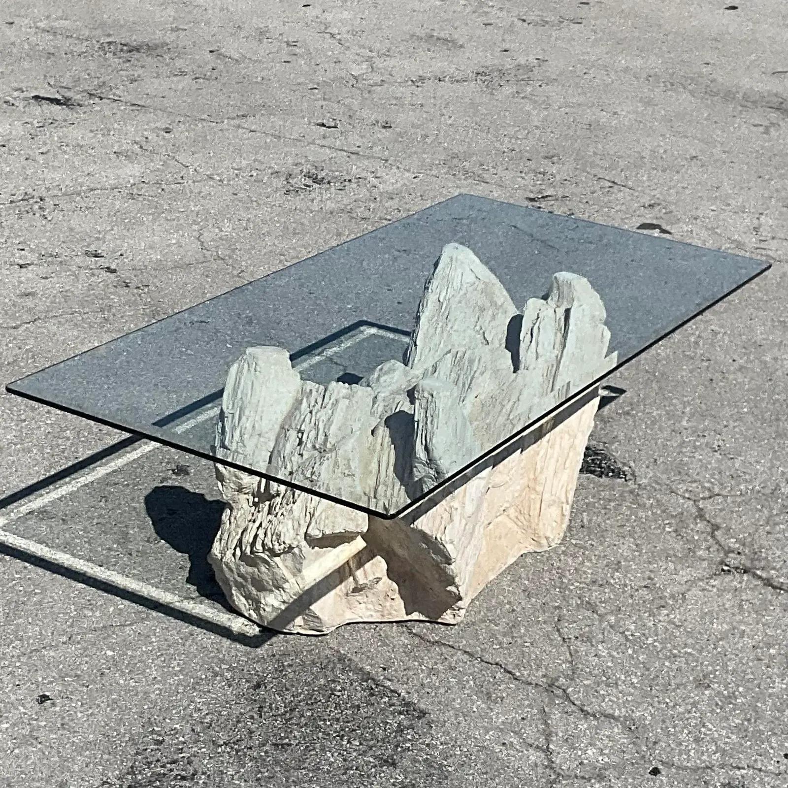 A fantastic vintage Boho coffee table. An amazing plaster rock formation done in the manner of Sirmos. Glass top rests on the rocks. Acquired from a Palm Beach estate.