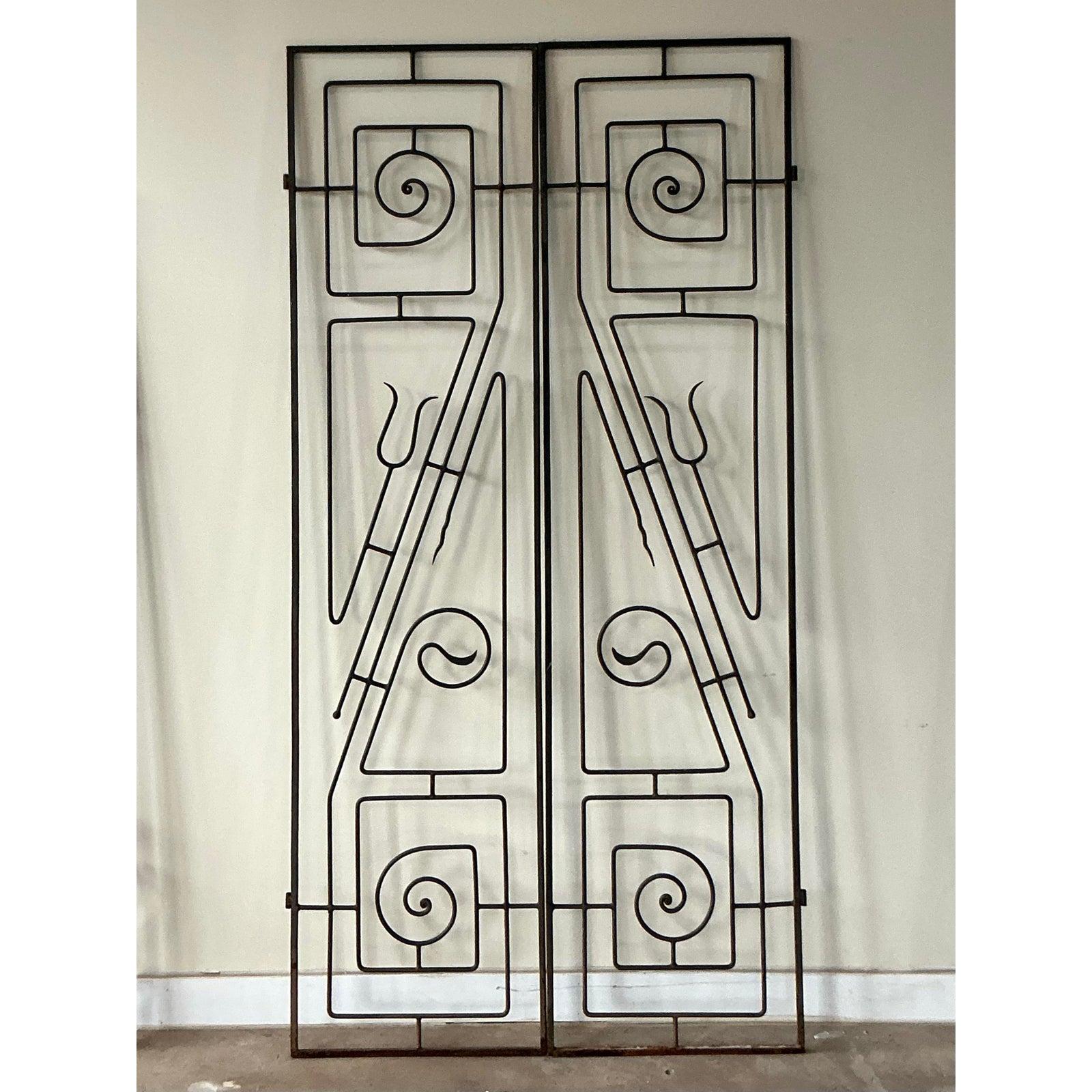 These striking wrought iron panels embody the bold, artistic spirit of Postmodern design, reminiscent of 1980s architectural sensibilities merged with streamlined Art Deco geometry. The intricate framework features a highly stylized, abstract