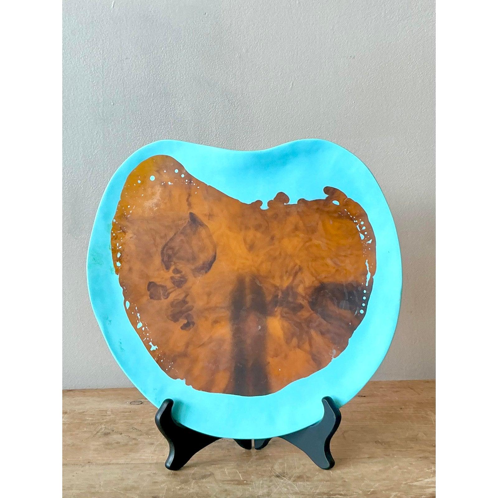 Abbraccia l'atmosfera artistica e libera di questo piatto decorativo vintage di ispirazione bohémien, caratterizzato da un'affascinante superficie in resina colata ornata da dettagli astratti in pittura. Questo pezzo unico mostra un sorprendente