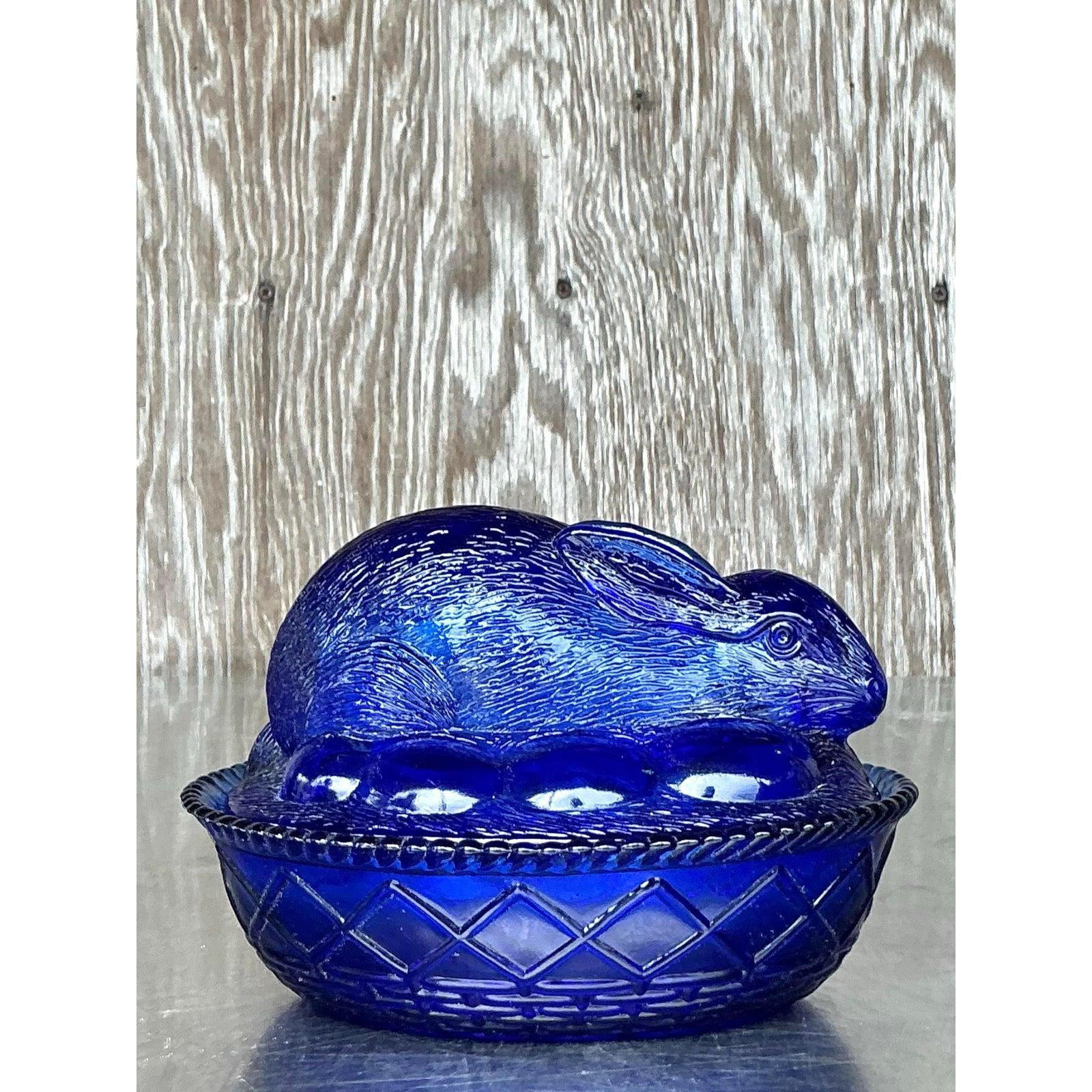 Apportez une touche fantaisiste à votre décoration avec ce bibelot à couvercle lapin en verre pressé boho vintage, une pièce charmante qui allie fonctionnalité et élégance nostalgique. Fabriqué en verre bleu cobalt vibrant, le couvercle en forme de