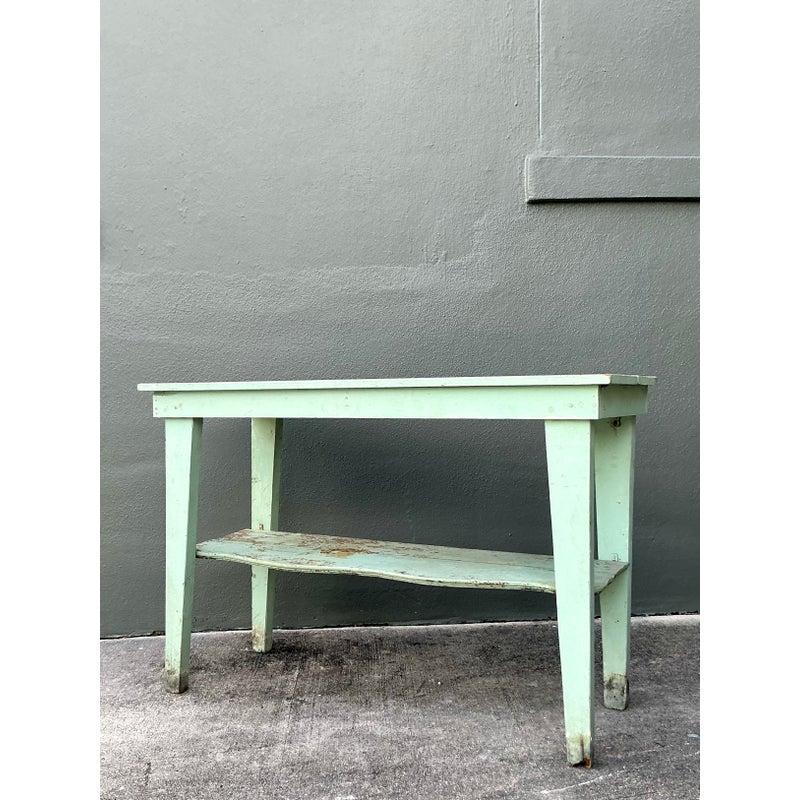 This authentic primitive console table is defined by its simple, rugged construction and deeply weathered surface, ideal for interiors embracing true rustic or Coastal charm. Constructed entirely from solid wood planks, the table features clean