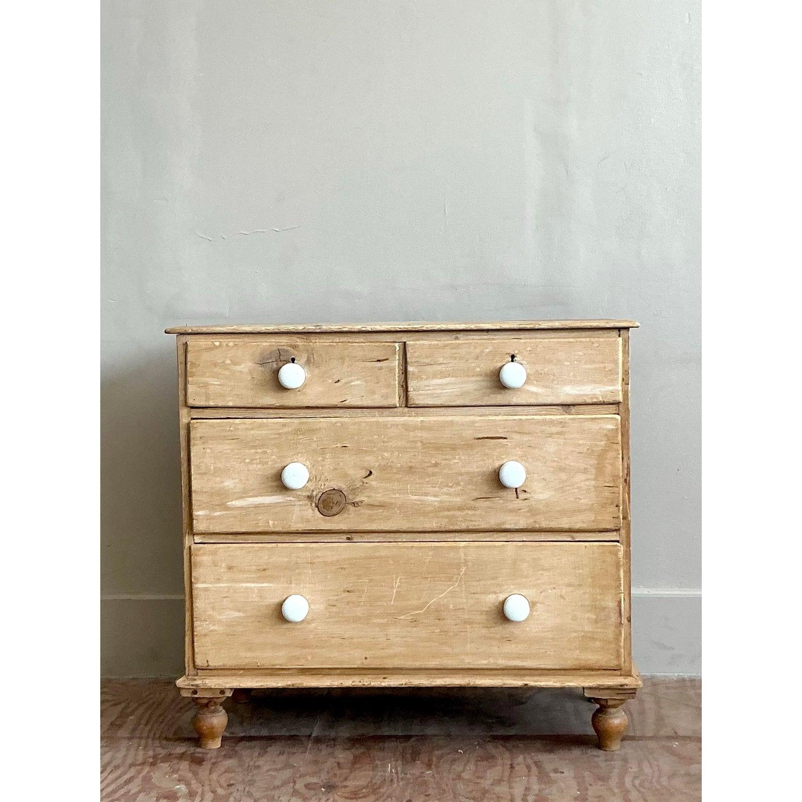 Radiating with honest charm and rustic simplicity, this vintage pine chest of drawers is a testament to timeless, unadorned design. Crafted from solid pine, the piece showcases a beautiful, light wood grain with a wonderfully scrubbed, natural