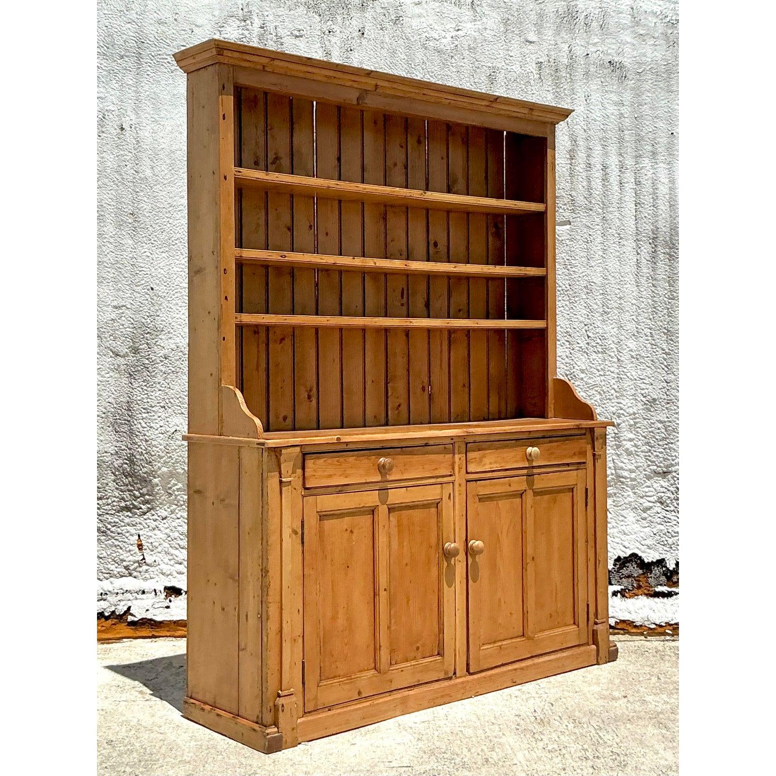 Embrace the enduring appeal of rustic simplicity with this magnificent vintage primitive pine hutch. A substantial and characterful piece, it showcases the natural beauty and warm grain of solid pine, crafted with a straightforward, honest design