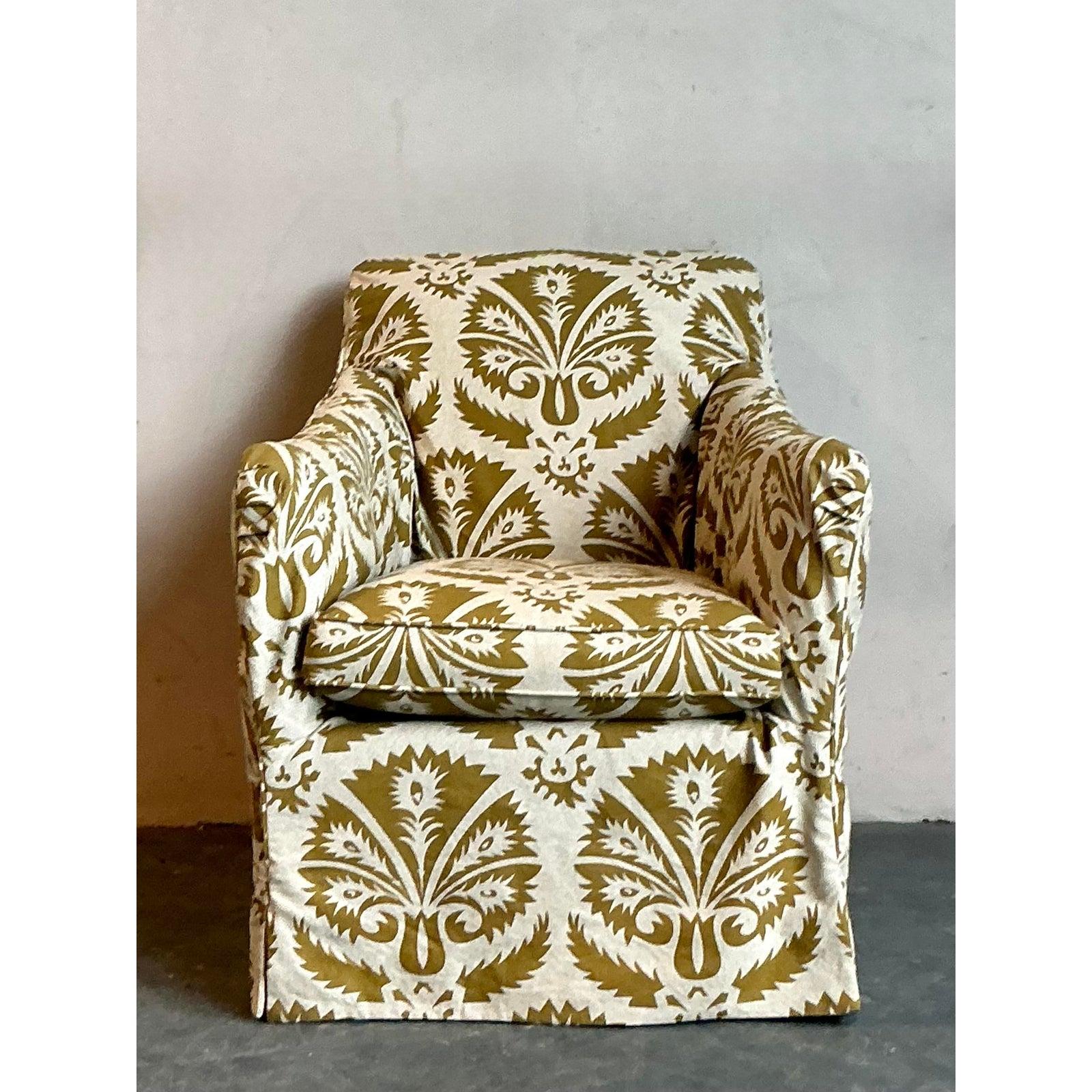 Dieser charmante Vintage-Sessel verkörpert mit seinem auffälligen Boho-Blumenprint einen entspannten, eklektischen Stil. Die großzügige, einladende Form ist vollständig in einen maßgeschneiderten Bezug gehüllt, ein beliebtes Designelement aus der