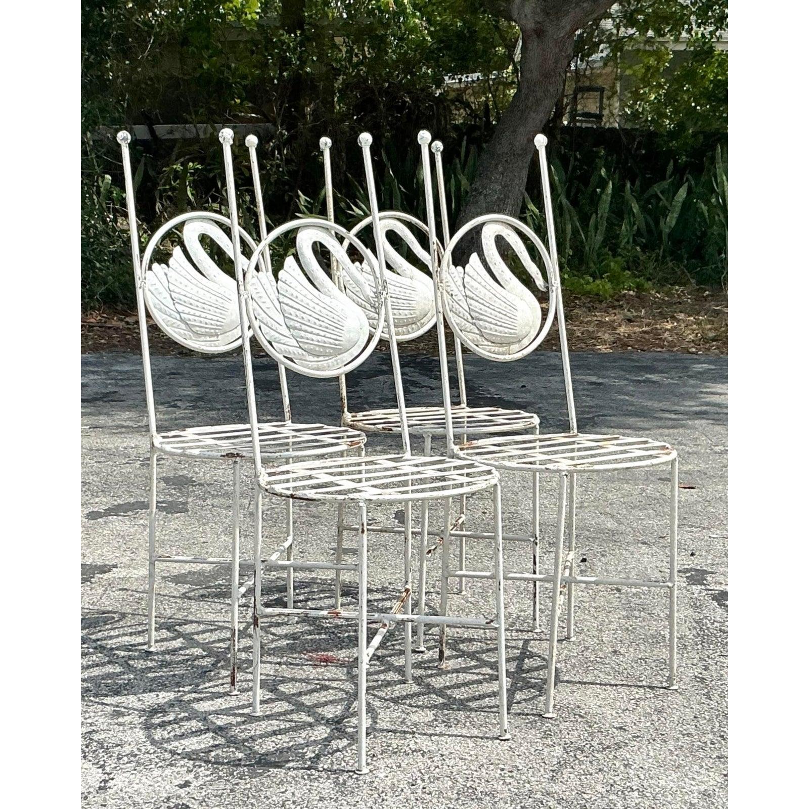 Bring a whimsical charm to your dining space or garden room with this striking set of four Vintage Boho Punch Cut Metal Swan Dining Chairs. Featuring sculptural swan backs with delicately punched metal detailing, these high-back chairs embody