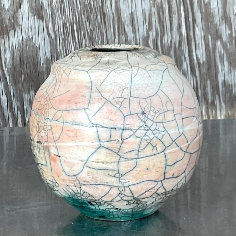 A fantastic vintage Boho vase. A chic Raku crackle finish in the most beautiful pale pink. Flashes of green peeking thru. Signed on the bottom. Acquired from a Palm Beach estate