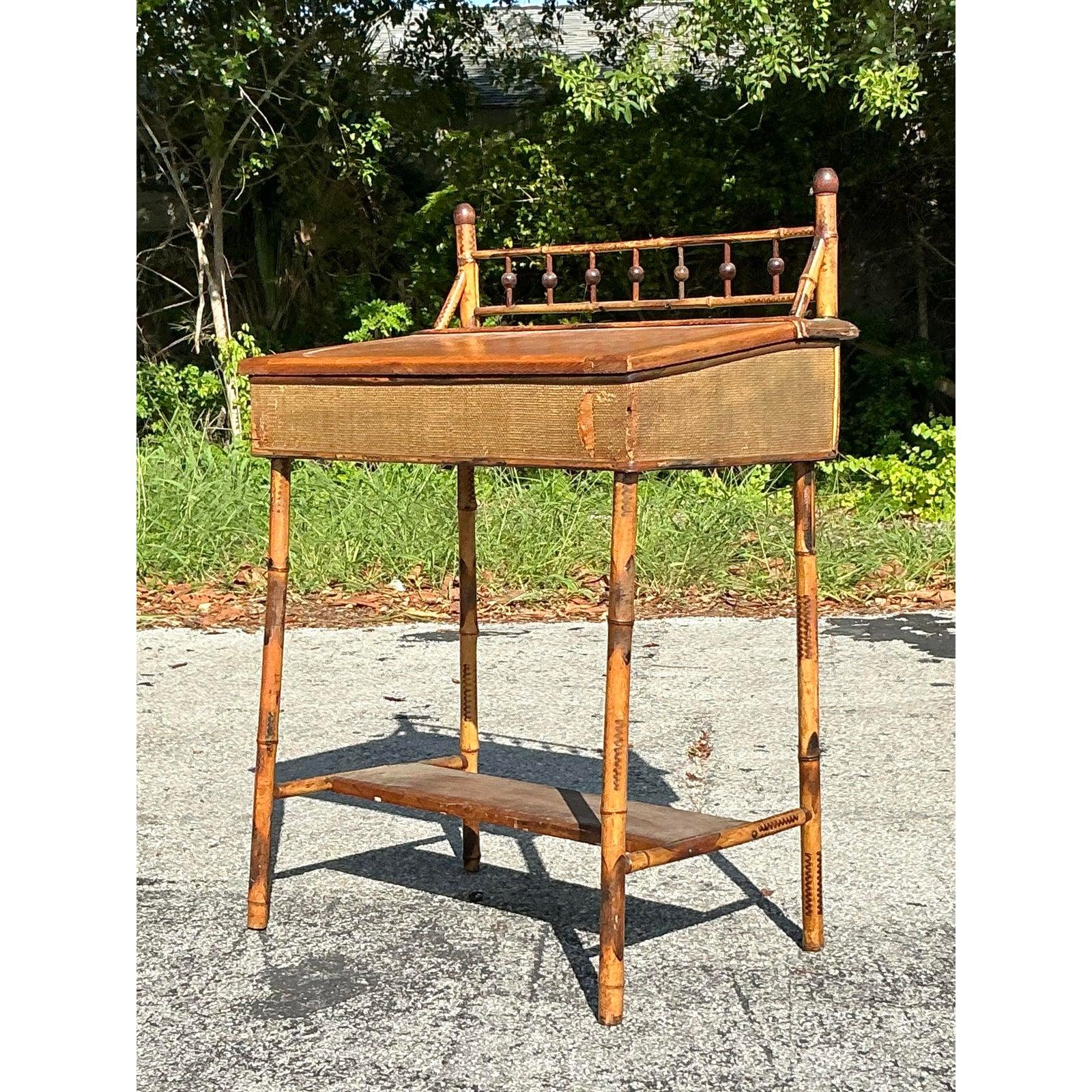 Eleganza e praticità sono le caratteristiche di questa scrivania lift top in rattan vintage Boho. La sua delicata struttura in bambù, accentuata da un caratteristico binario a galleria con dettagli di fuso tornito e ricchi pannelli in rattan